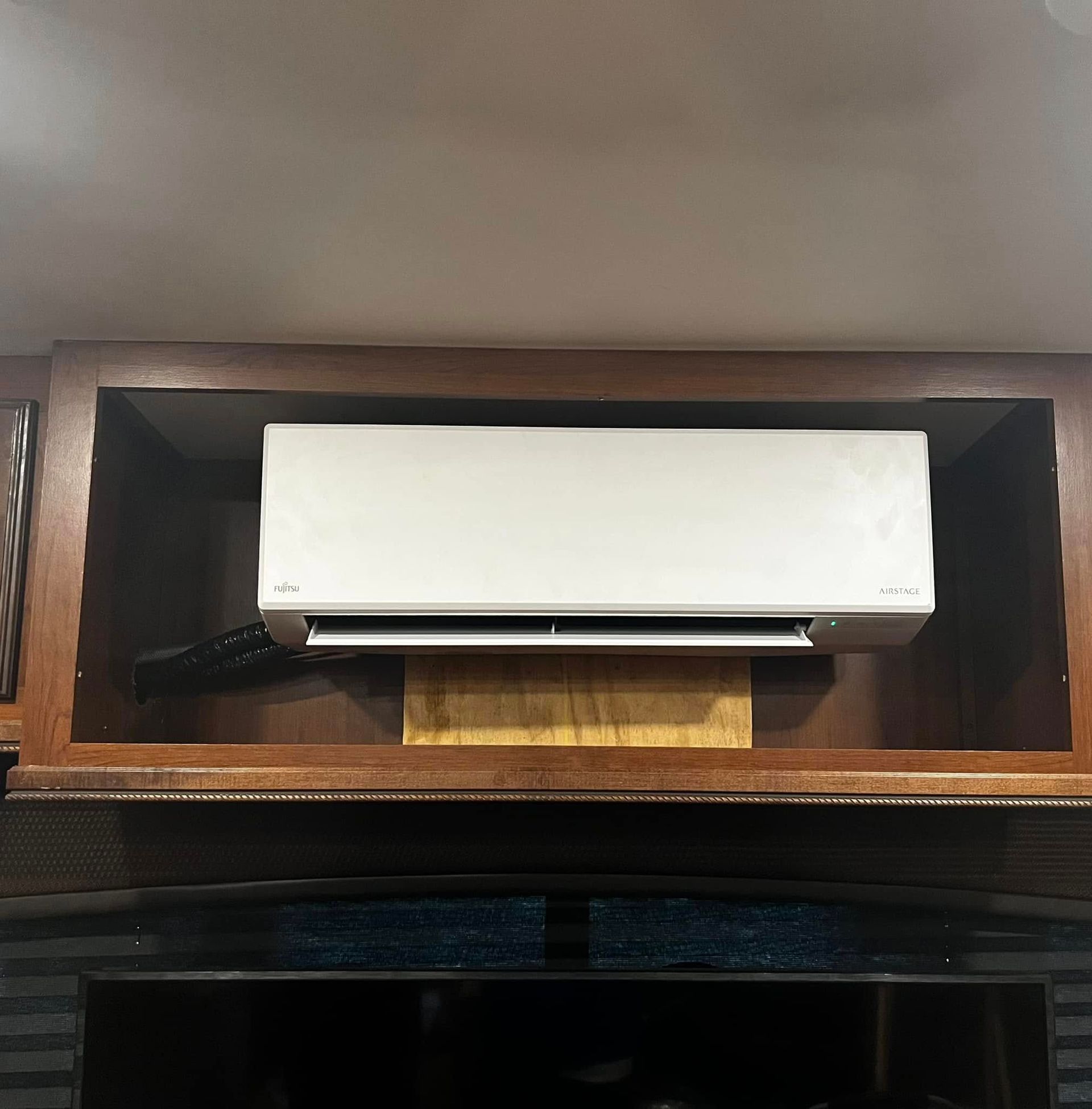 Air conditioning unit outside on concrete pad near brick wall, with gauges attached.