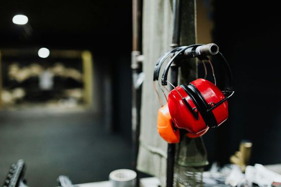 A pair of red ear muffs hanging on a pole.