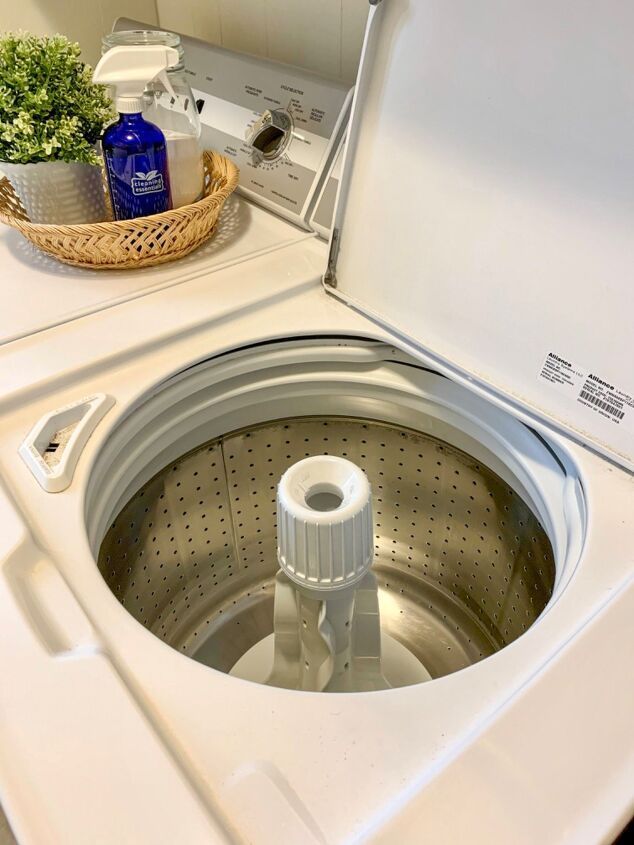 Washing machine with its top removed for repair, showing internal components and tools.