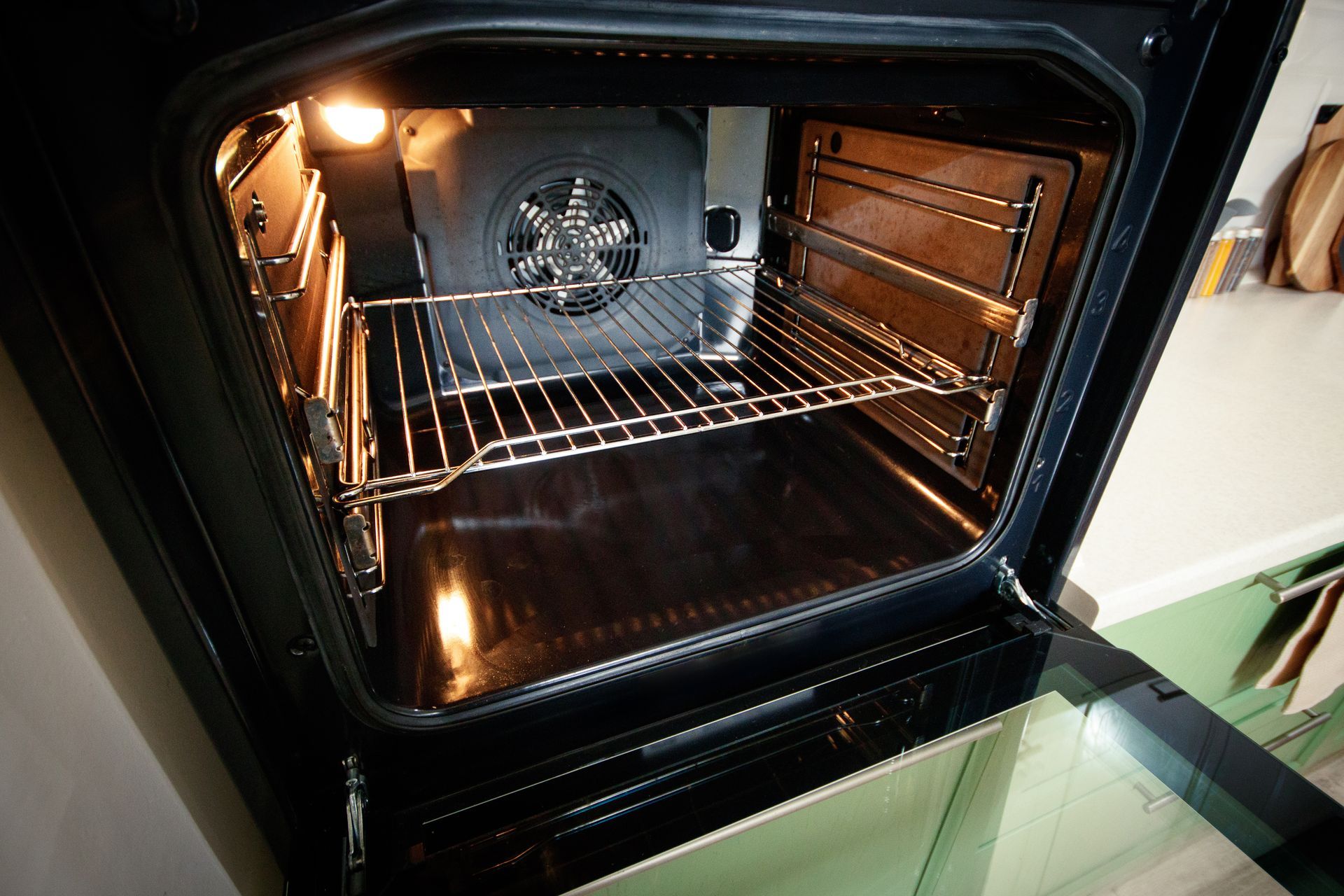 Open oven interior with racks and a fan.