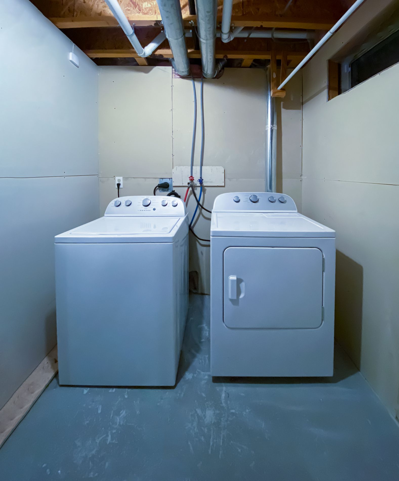 Washing machine tub disassembled, showing the stainless steel drum and plastic outer casing, outdoors.