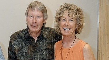 Man transporting a white oven, secured with straps, using a dolly inside a home. Man transporting a white oven, secured with straps, using a dolly inside a home.