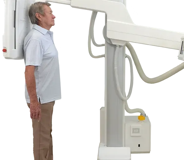 A man is standing in front of an x-ray machine