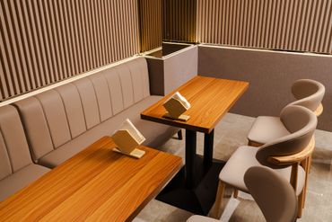 小型私人用餐包廂，配有木桌、米色椅子和條紋牆板。