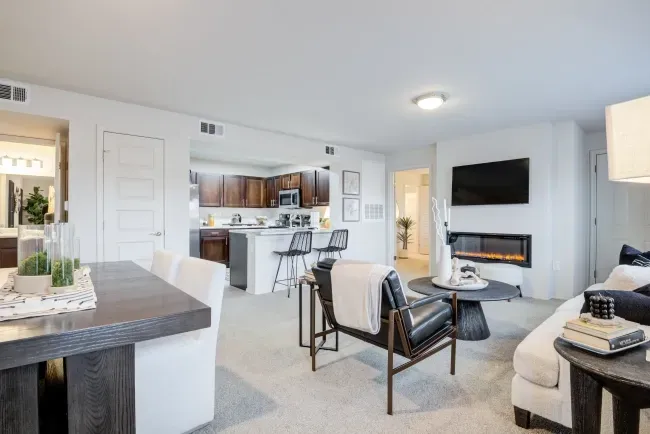 Modern apartment living area with kitchen visible in background