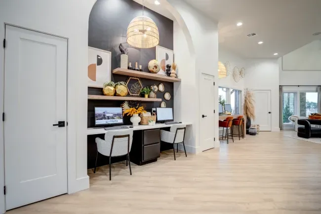 Modern communal workspace with two desks and decorative wall.