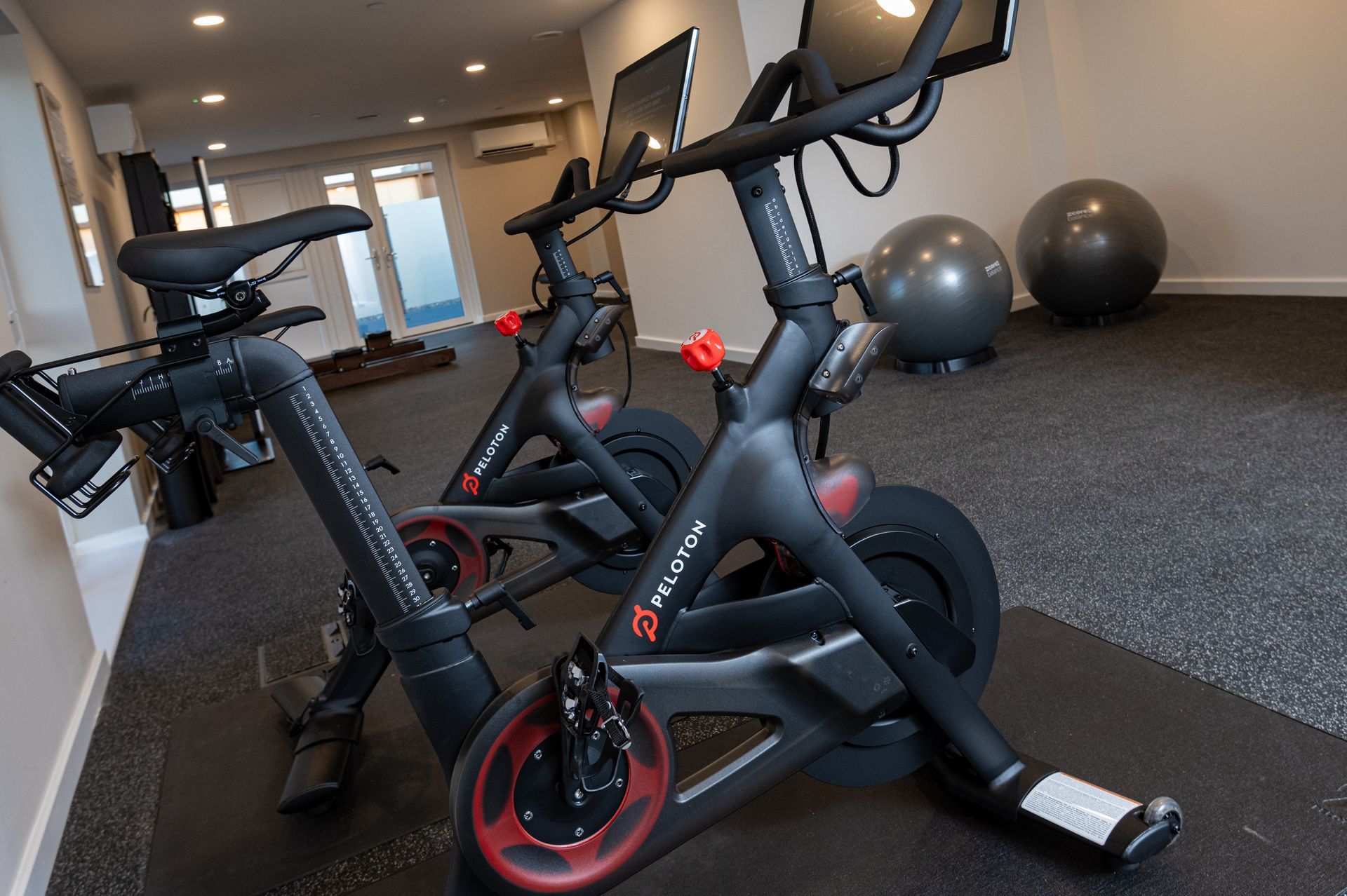 Two peloton exercise bikes are lined up in a gym at Walton Court.