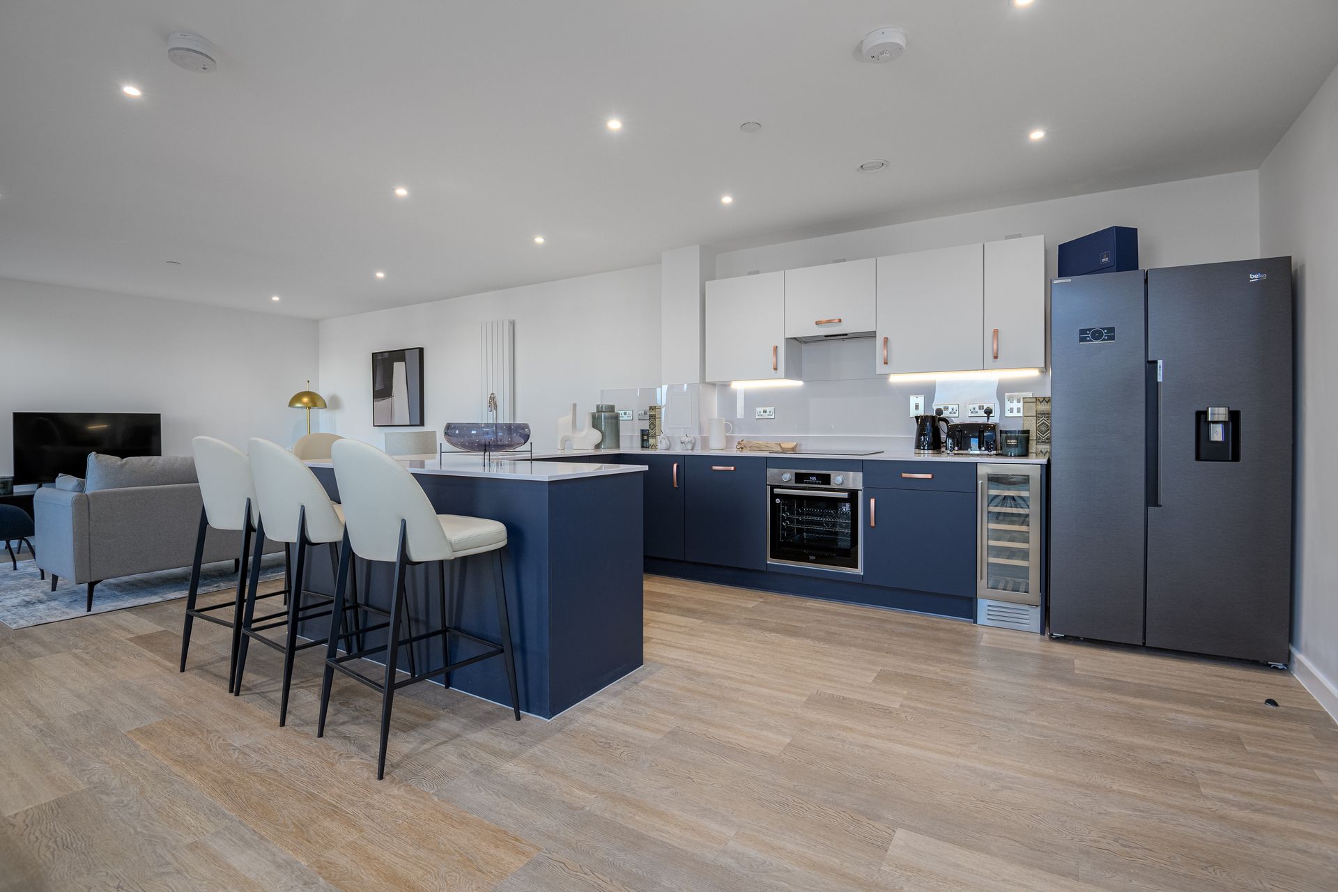 A kitchen with blue cabinets , white cabinets , stainless steel appliances and a refrigerator at Walton Court.