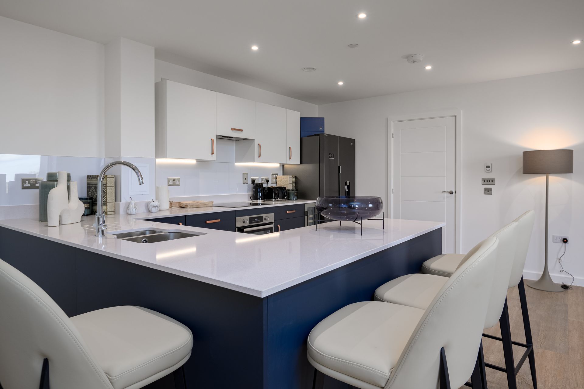 A kitchen with blue cabinets and white counter tops at Walton Court.