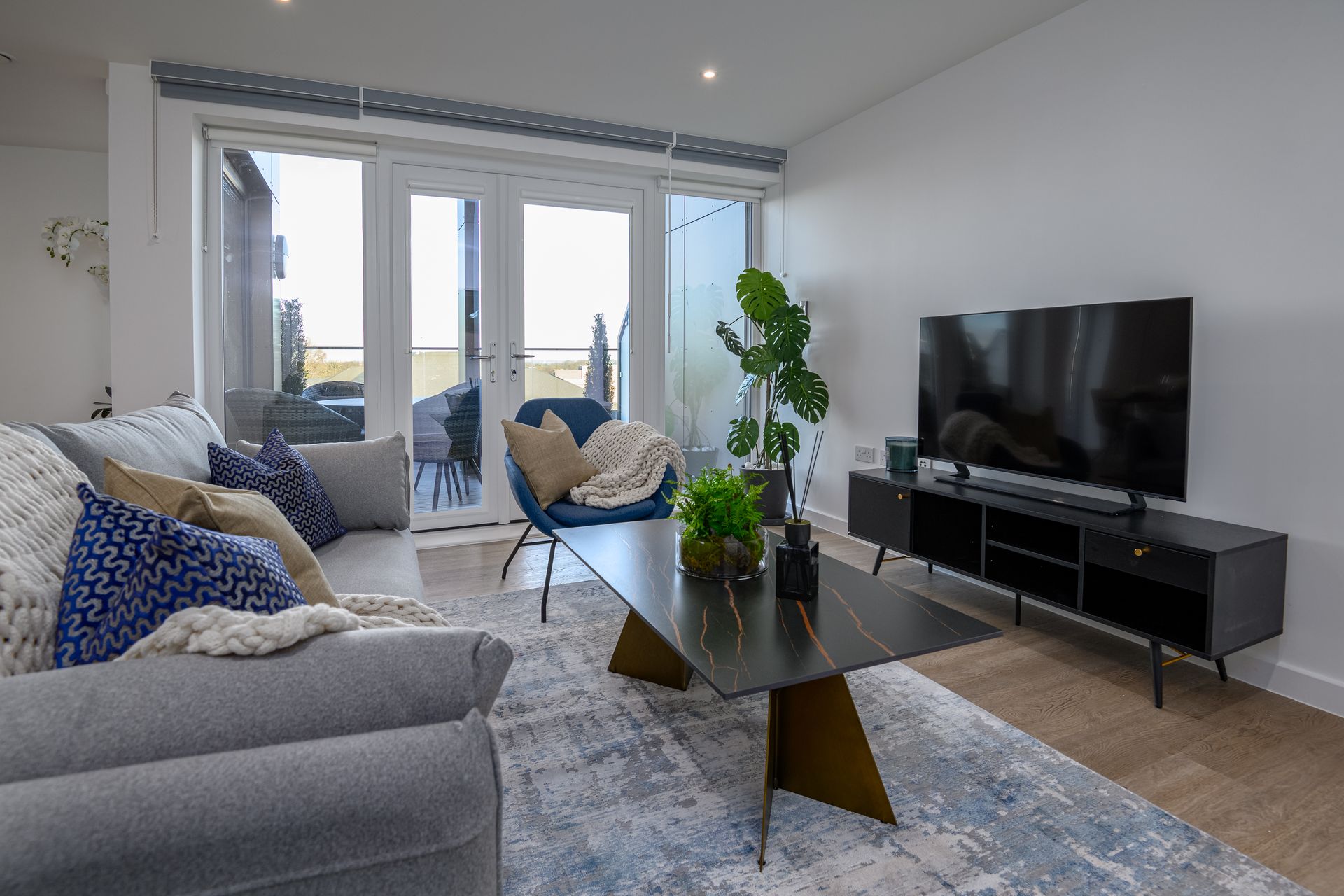 A living room with a couch , chair , coffee table and television at Walton Court.