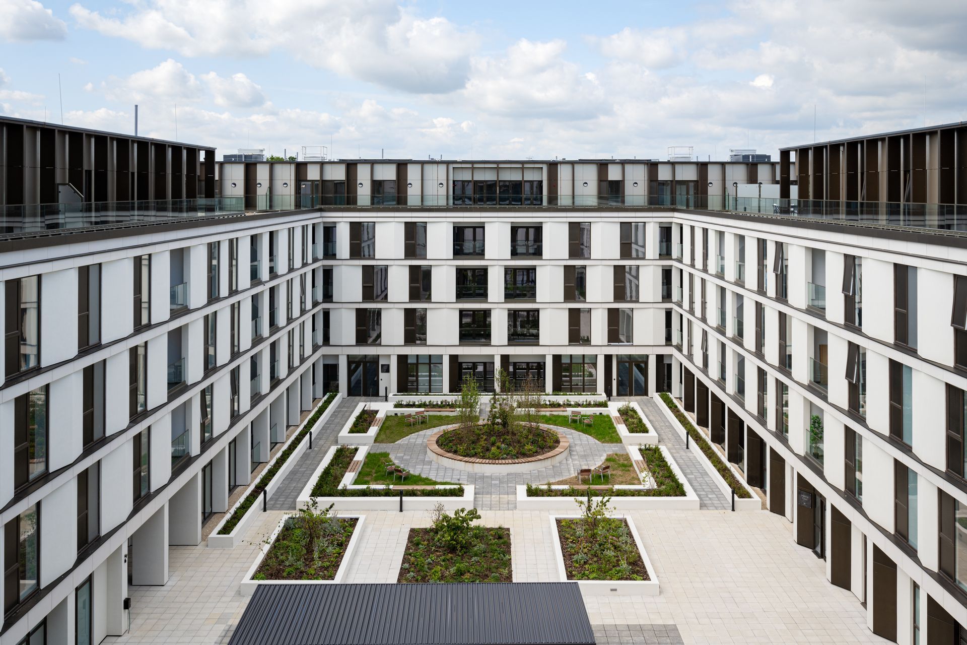 An artist 's impression of a courtyard between two large buildings.