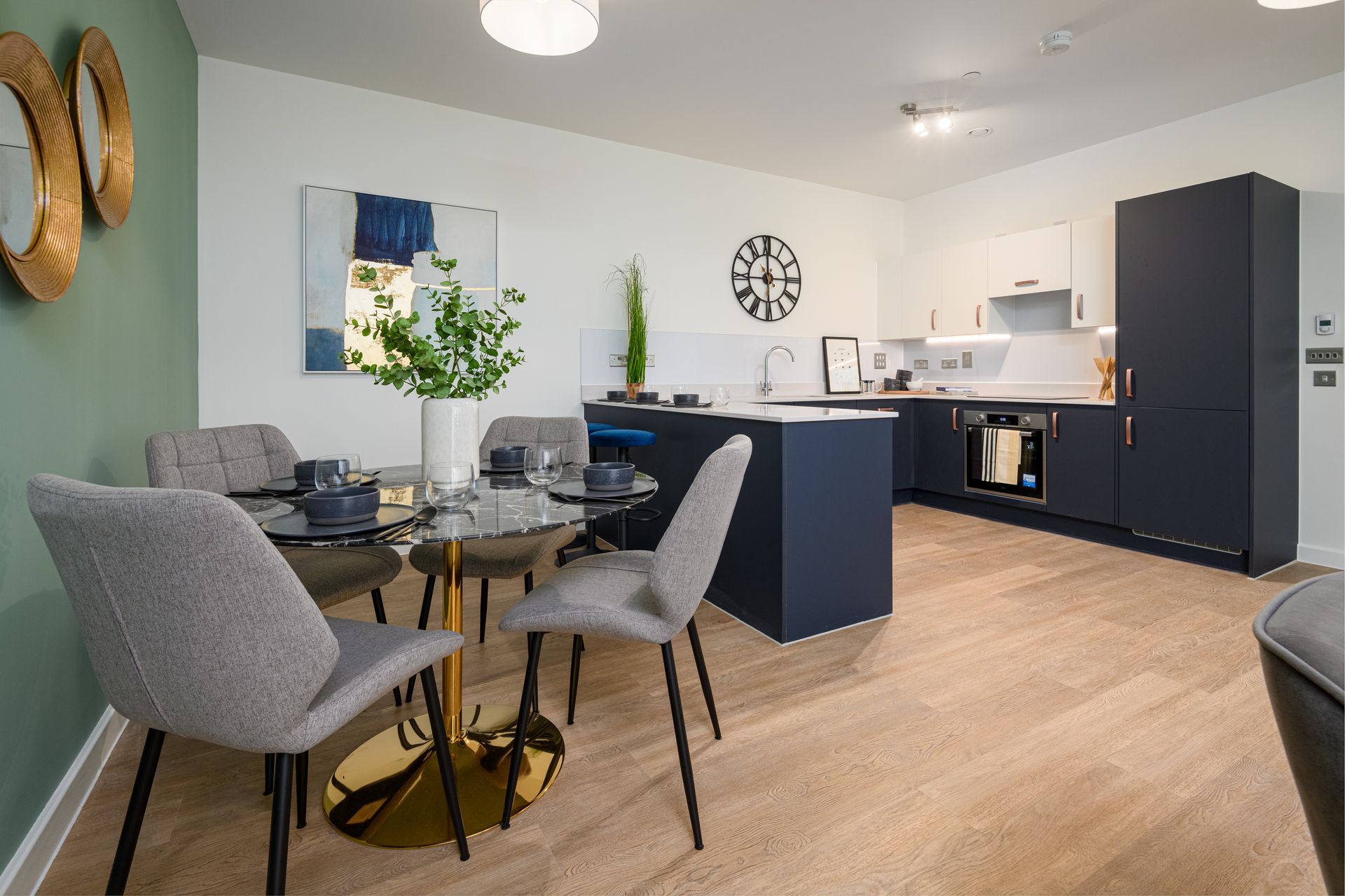 A kitchen with a dining table and chairs and a clock on the wall at Walton Court.