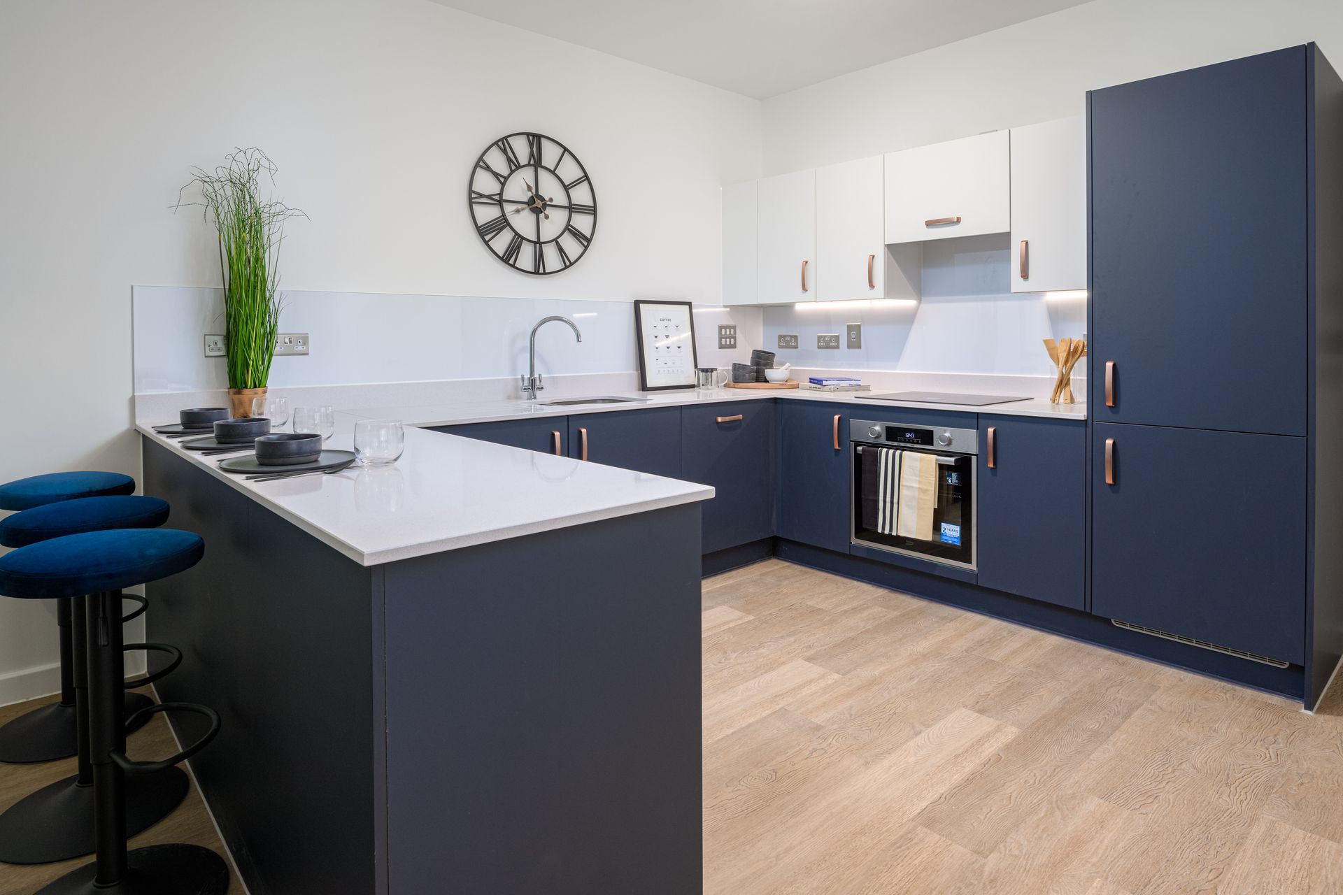 A kitchen with blue cabinets and a clock on the wall at Walton Court.