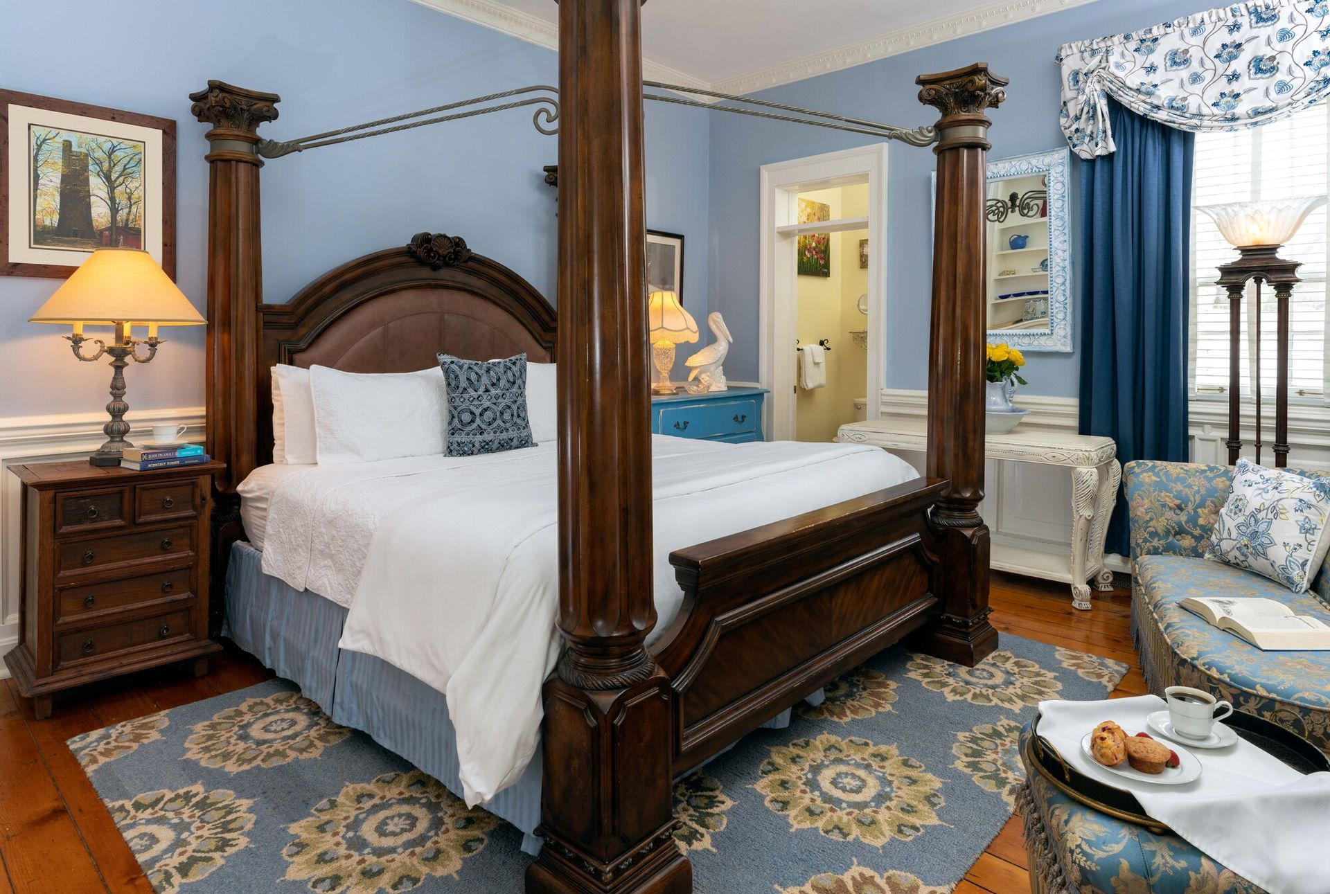 A bedroom with a sleigh bed and a table with food on it