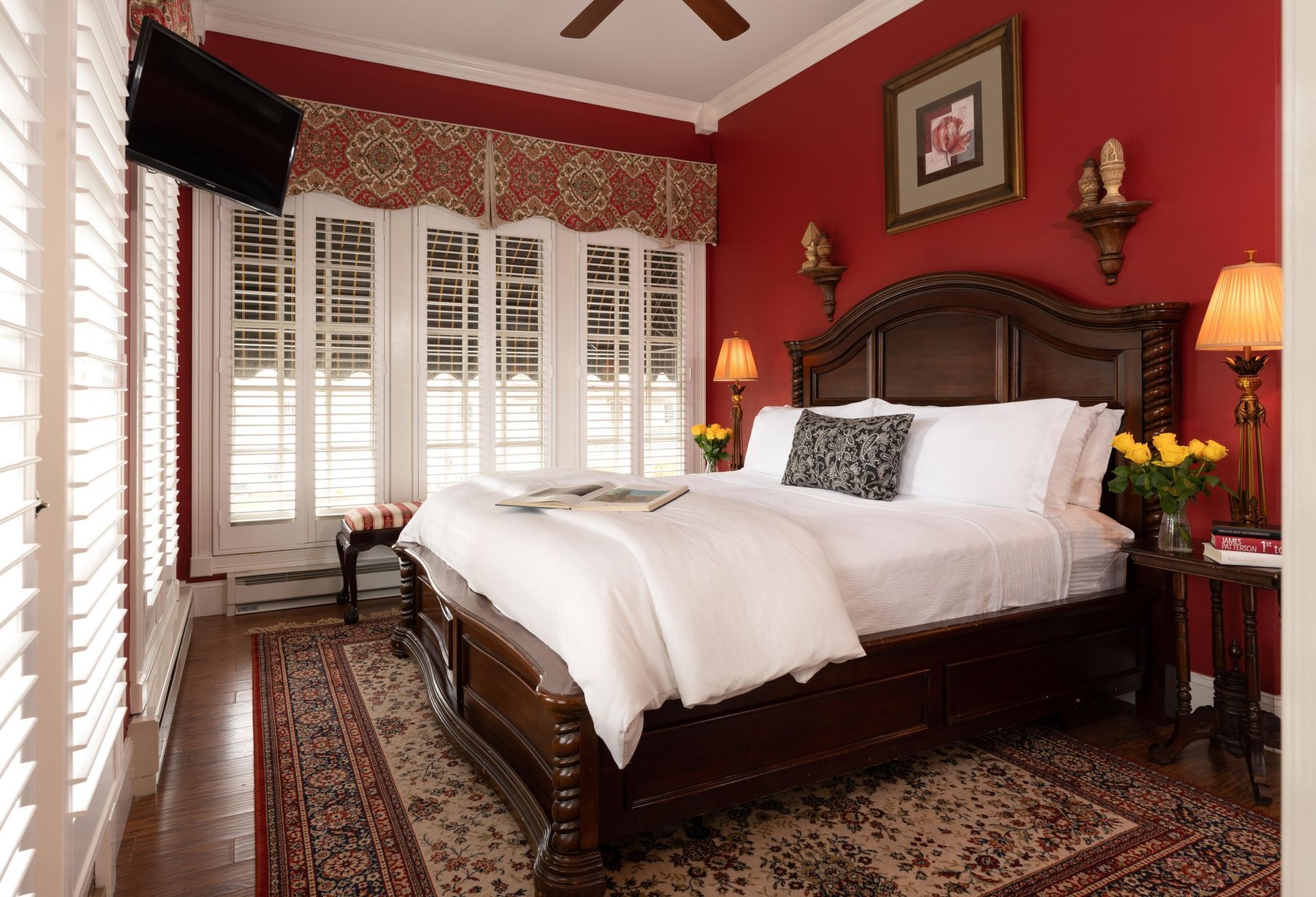 A bedroom with a sleigh bed and a table with food on it
