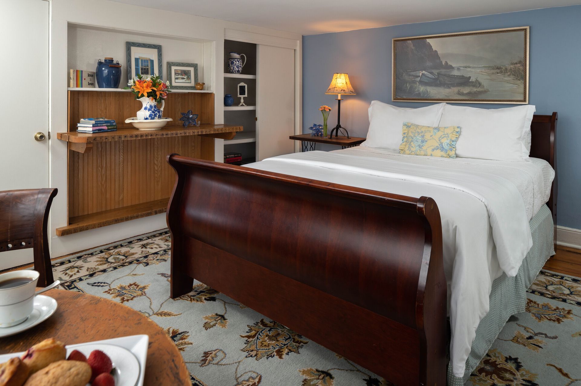 A bedroom with a sleigh bed and a table with food on it