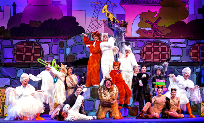 Cats musical stage production: Dancers in cat costumes, posing, on a colorful set.