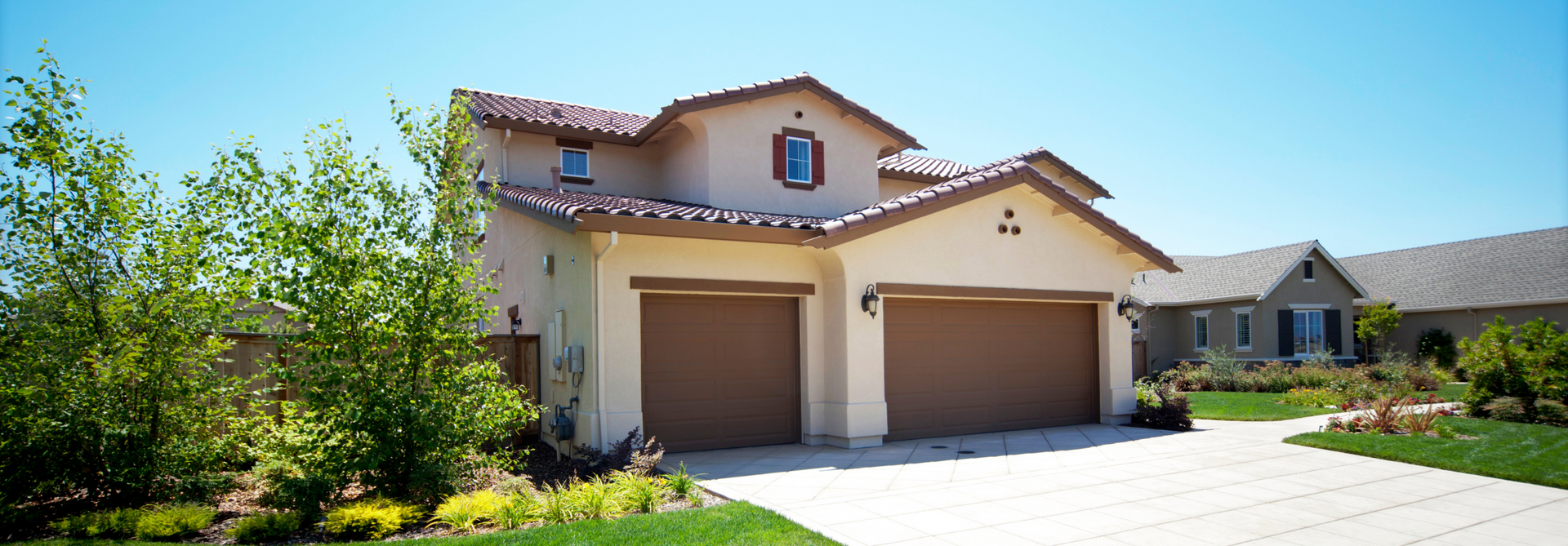 A large san diego house with two garage doors and a driveway