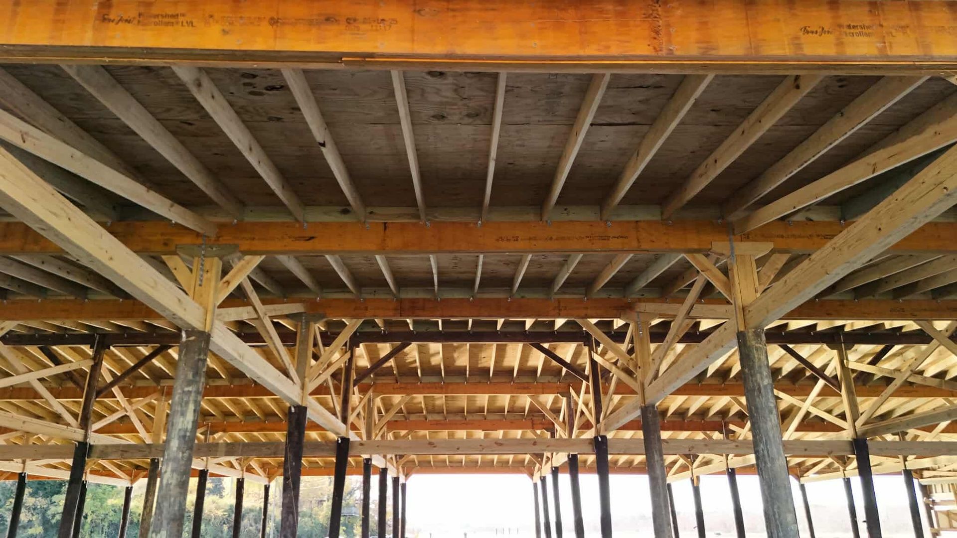 Wooden structure under construction, rafters and beams visible.