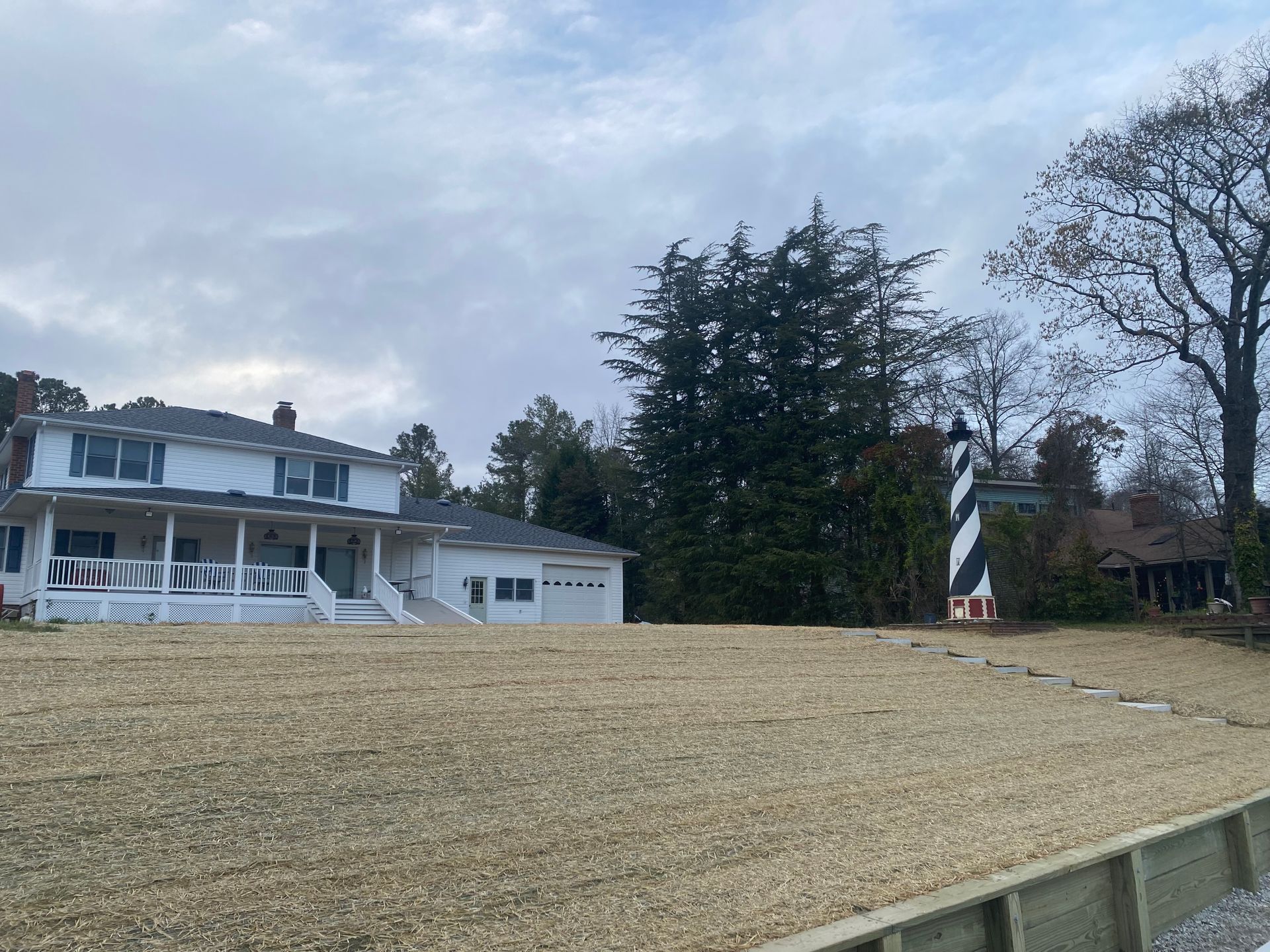 White house with a small lighthouse, on a cloudy day.