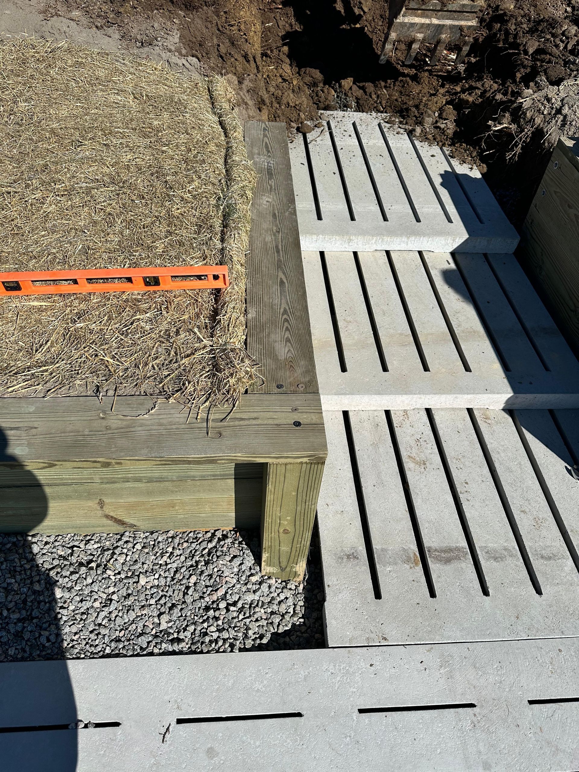 Steps being built: gravel, timber, and concrete slabs. Level in use.