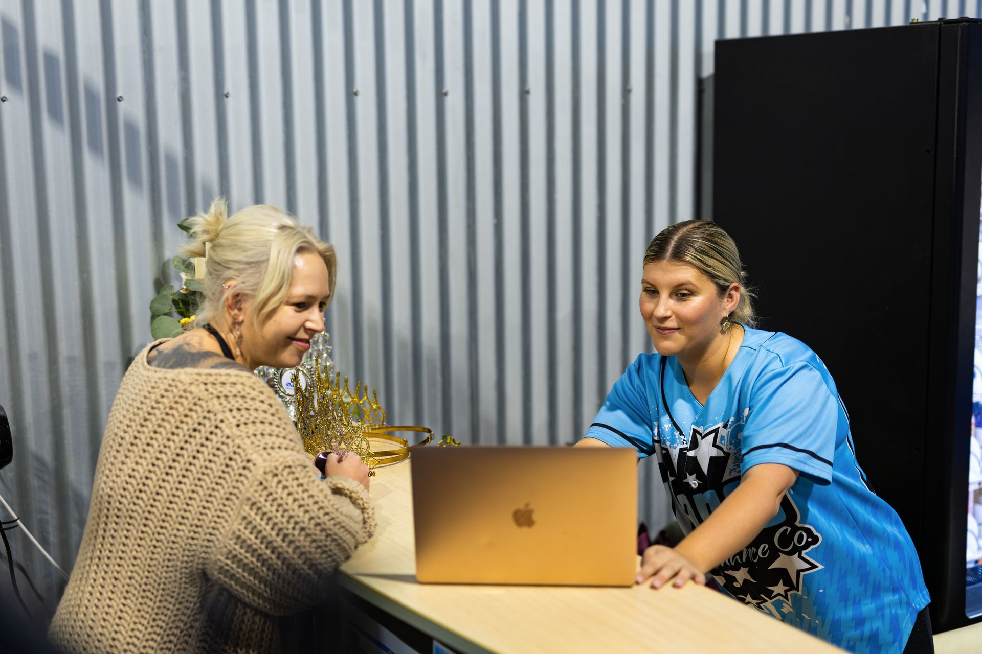 Two People at a Desk, Looking at a Laptop. One Wears a Tan Sweater — iDance Performance Co In Medowie, NSW