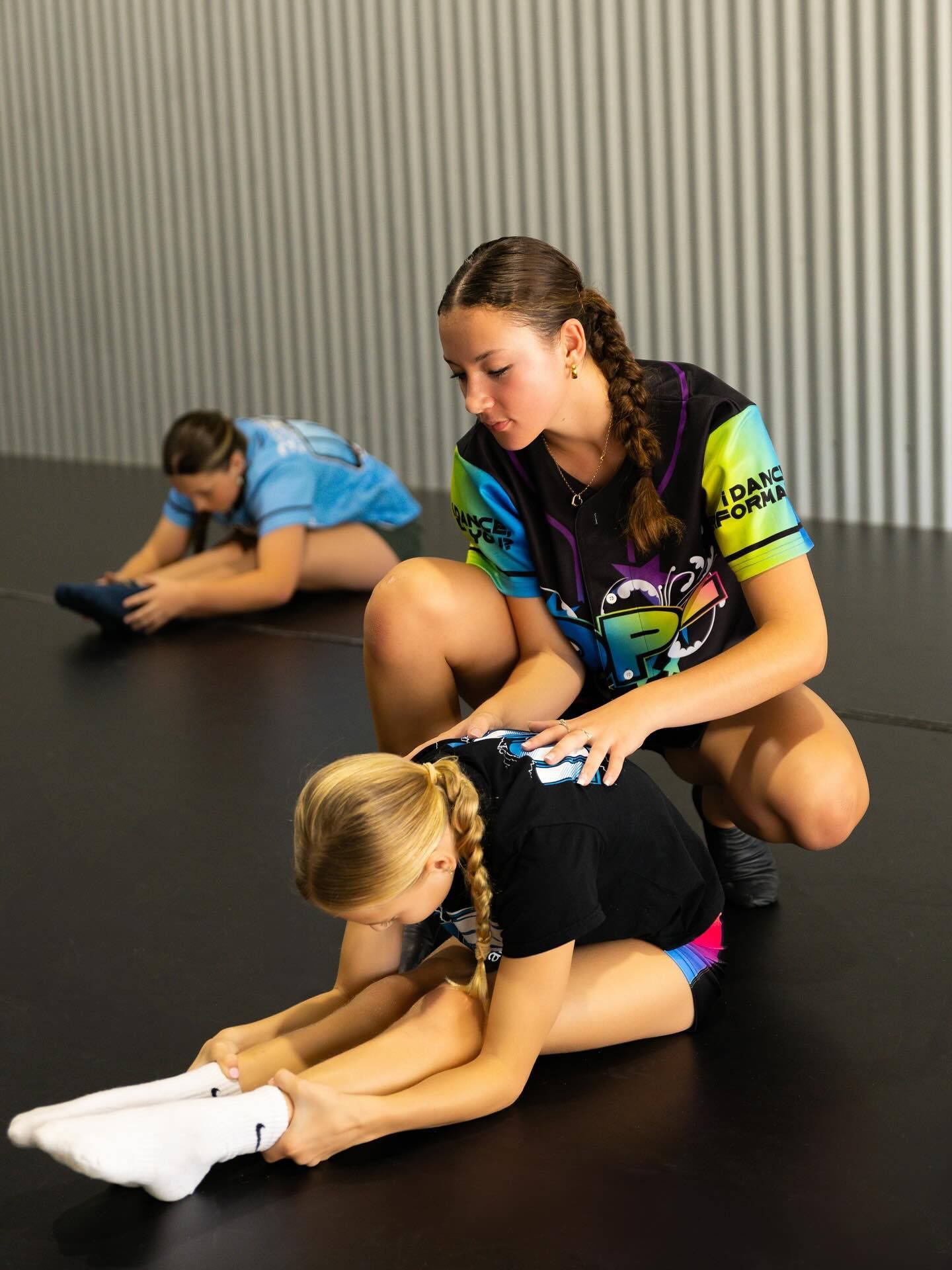 Three People Stretching on a Black Floor in a Studio — iDance Performance Co In Medowie, NSW