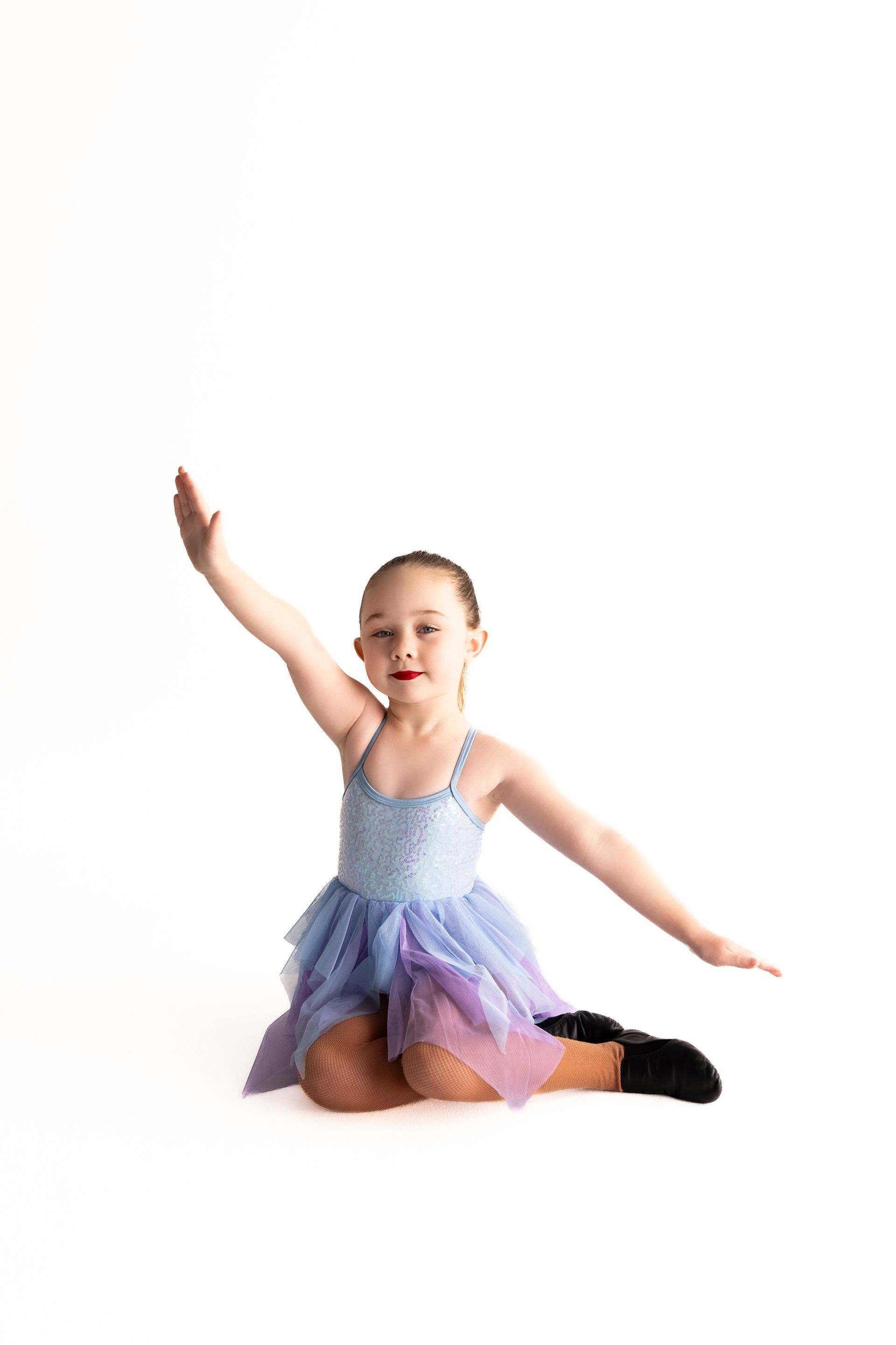 Young Dancer in Blue Dress, One Arm Raised, Seated on Floor — iDance Performance Co In Medowie, NSW