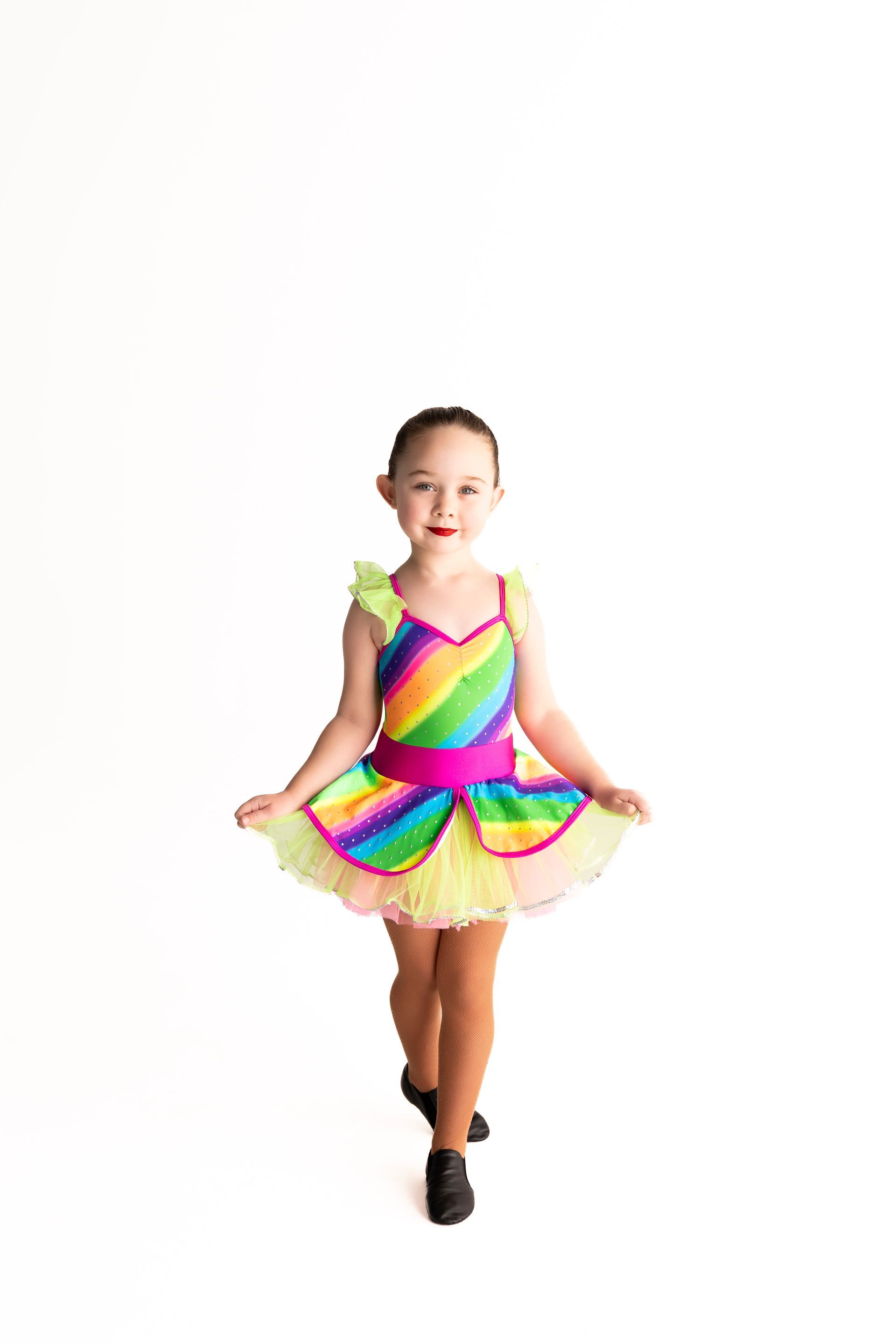 Girl in a rainbow dance costume smiles — iDance Performance Co In Medowie, NSW