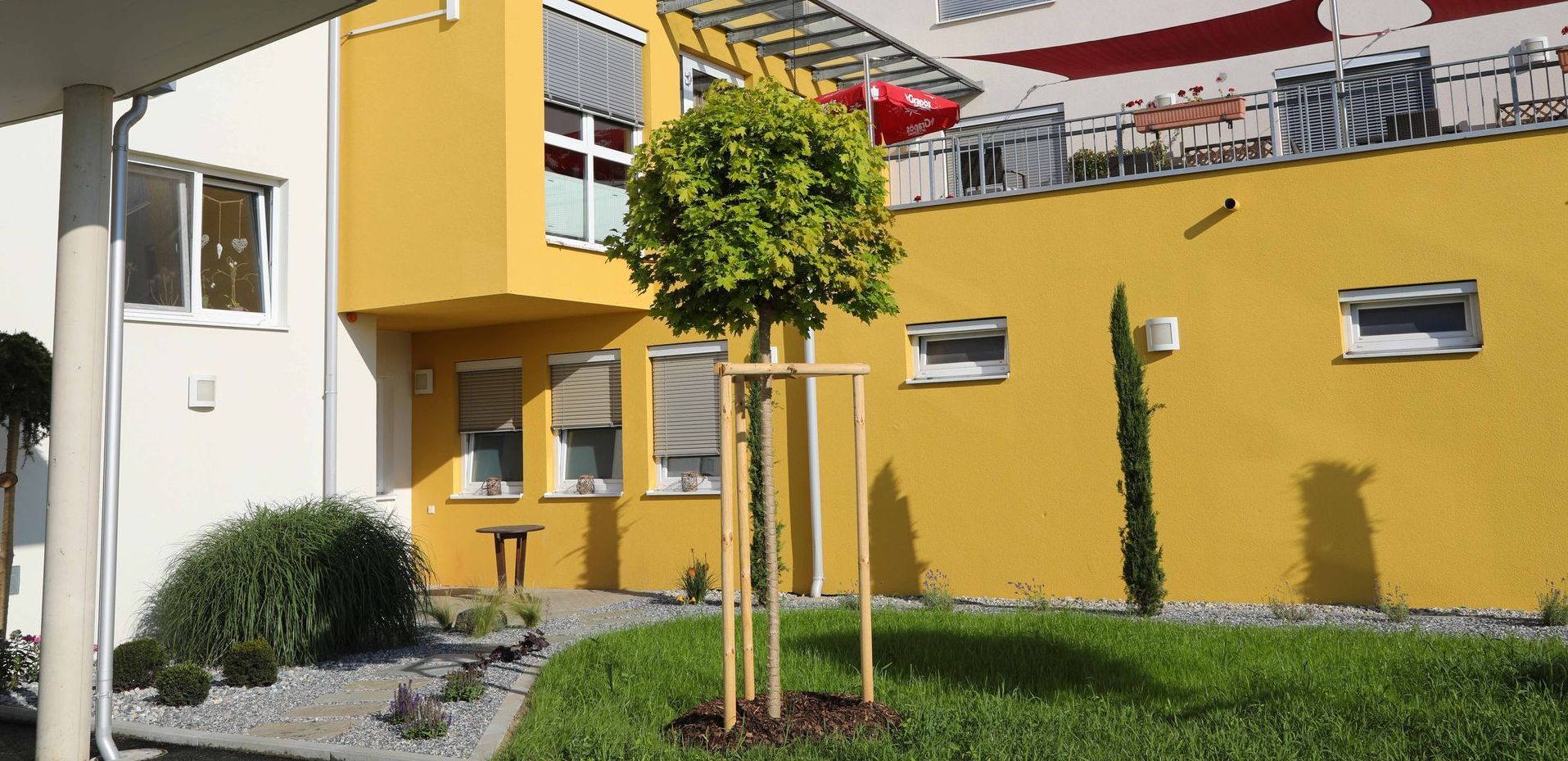 Ein gelbes Gebäude mit einem Baum davor