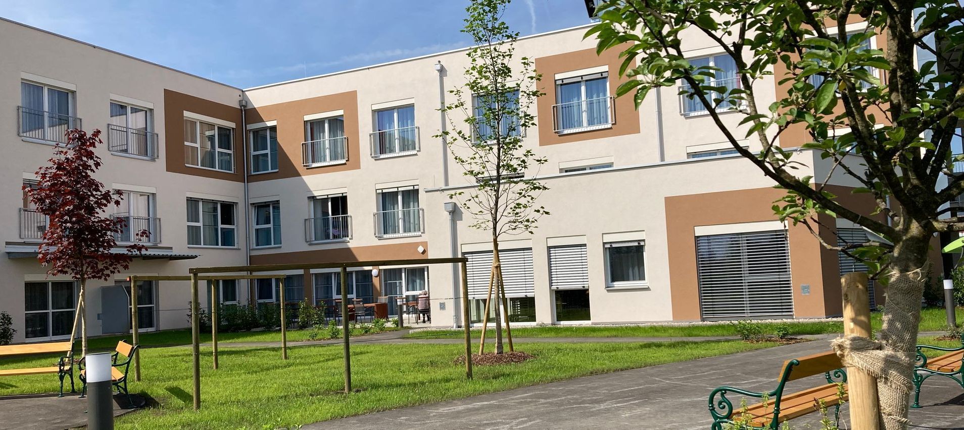 Ein großes Gebäude mit vielen Fenstern und Bäumen davor.
