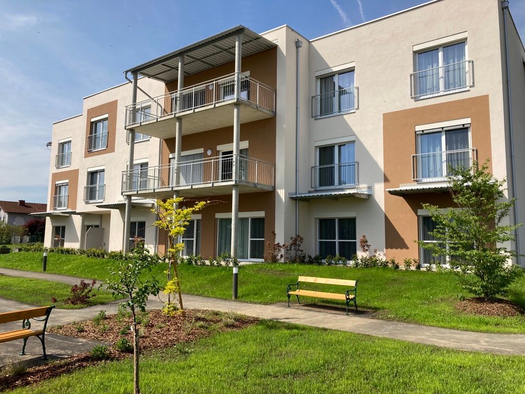 Ein großes Wohnhaus mit einer Bank davor