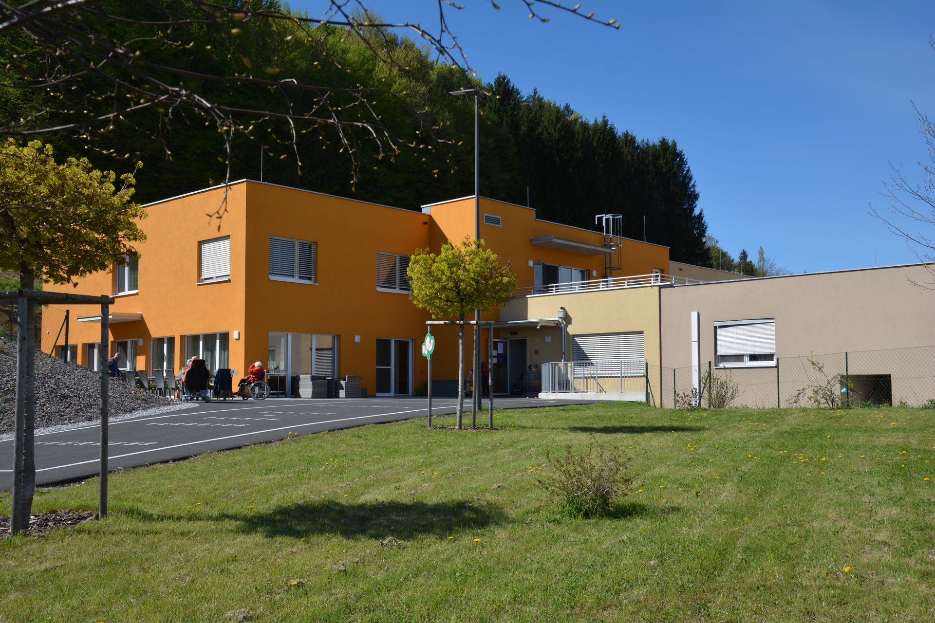 Ein großes orangefarbenes Gebäude mit Bäumen davor