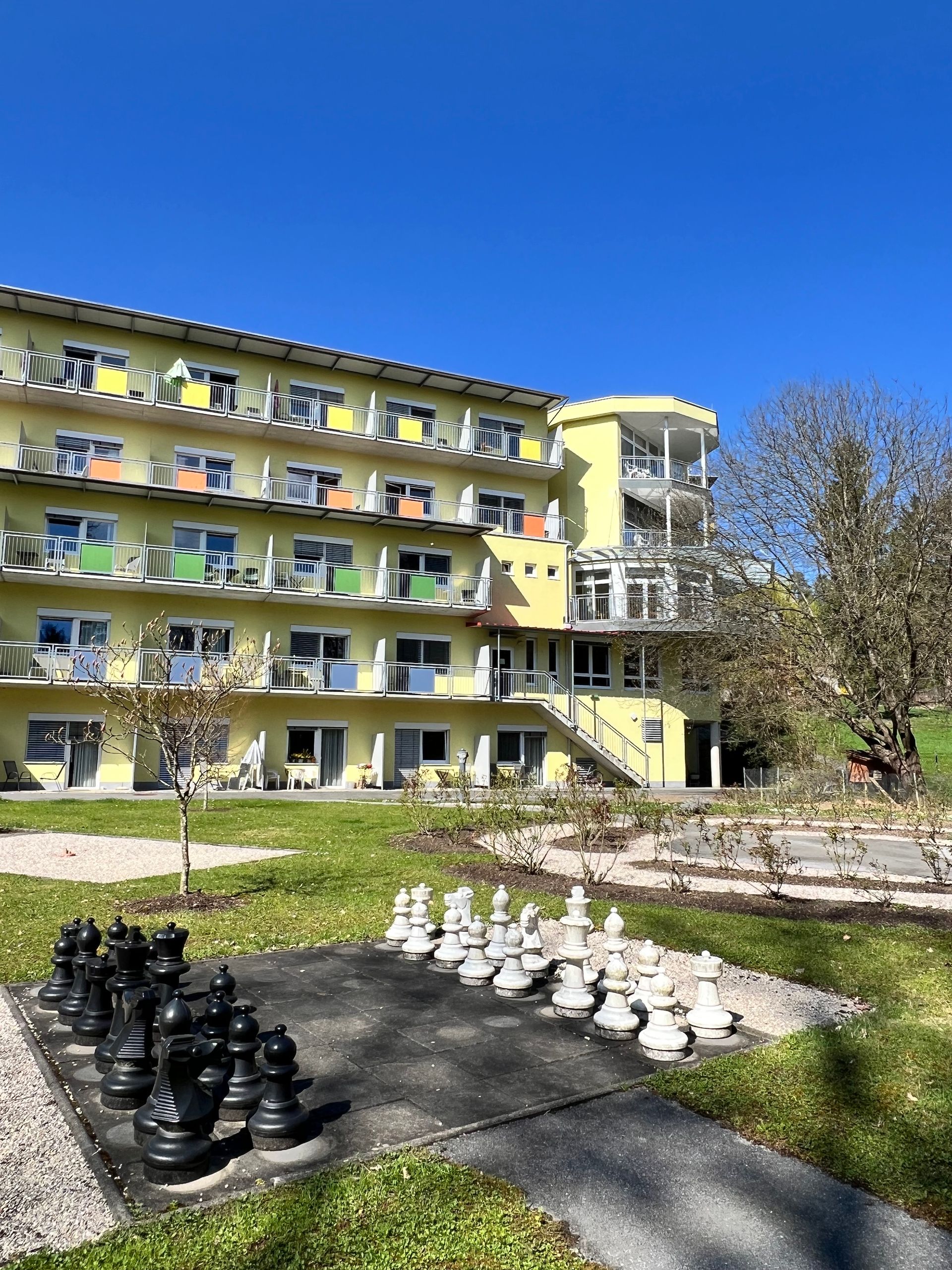 Vor einem großen Gebäude steht ein großes Schachbrett.