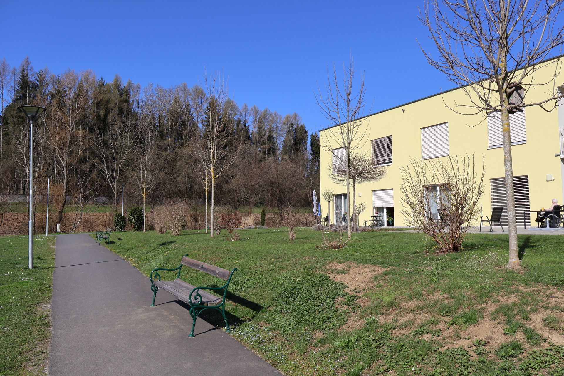 Ein Park mit einer Bank und einem Gebäude im Hintergrund