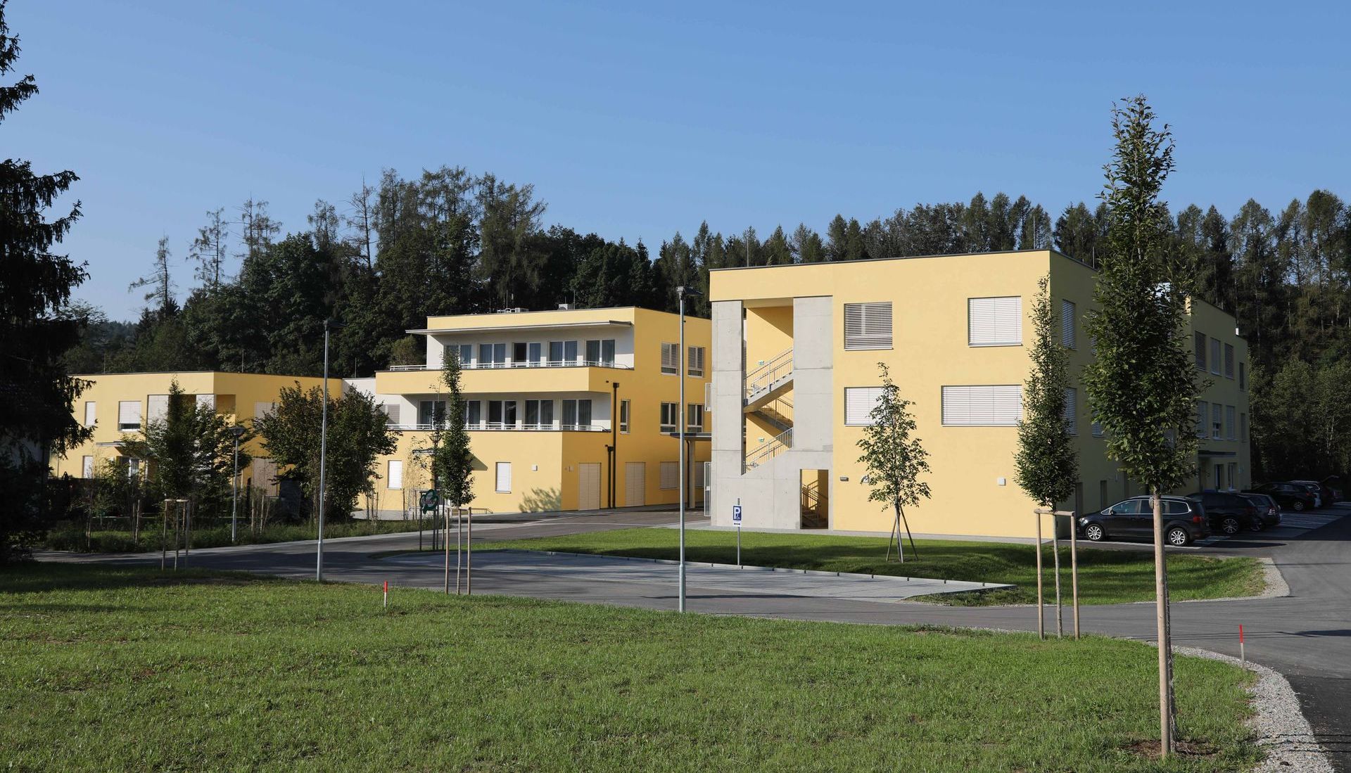 Ein großes gelbes Gebäude mit Bäumen im Hintergrund