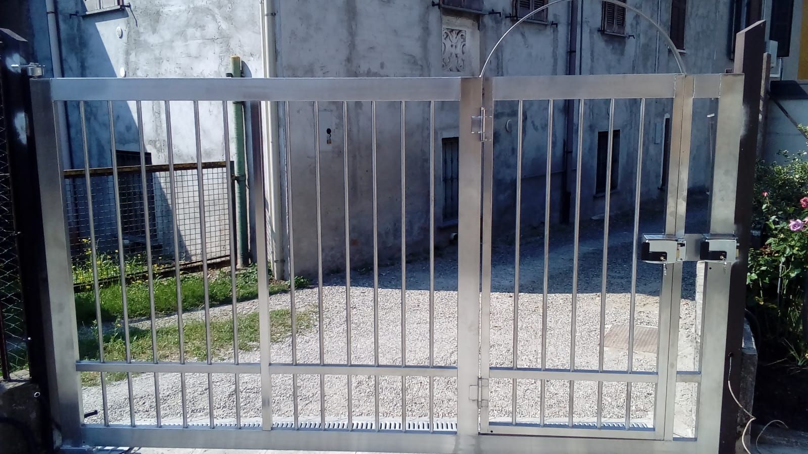 Un cancello in acciaio inossidabile è aperto davanti a un edificio