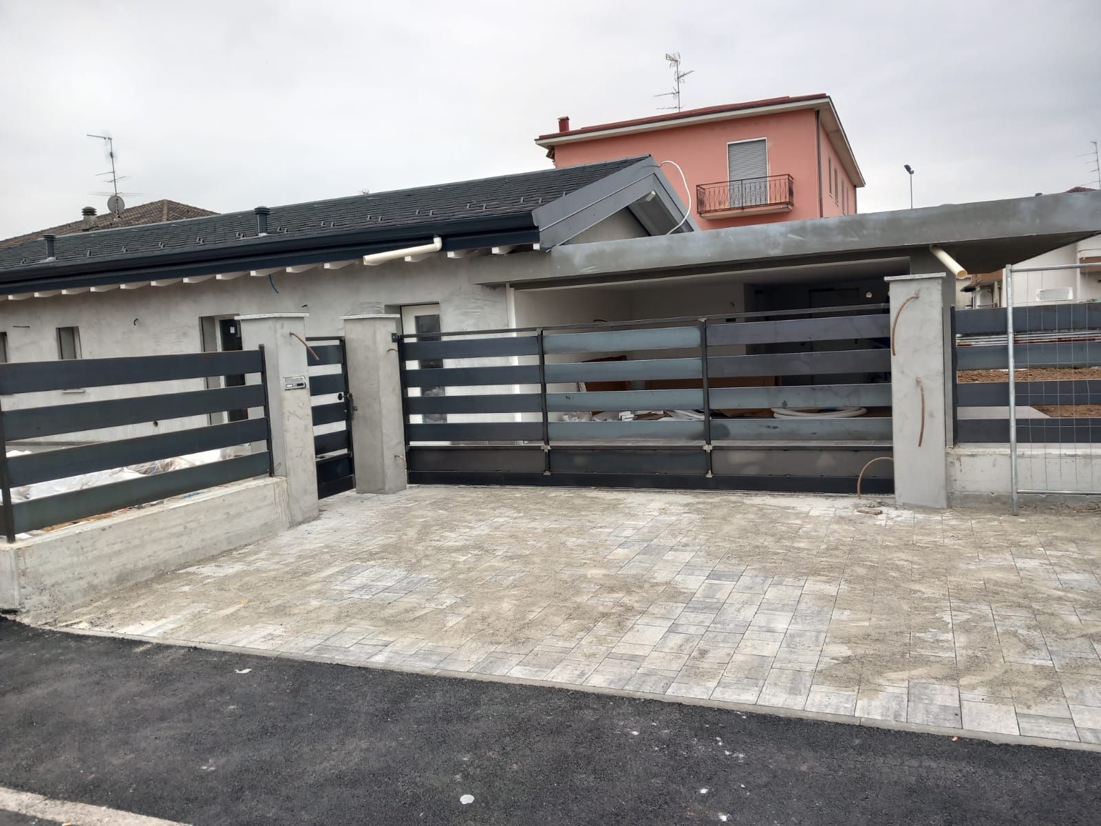 Una casa con una recinzione e un cancello davanti