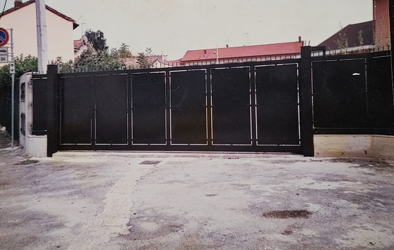 Un cancello nero è posizionato in mezzo a un parcheggio