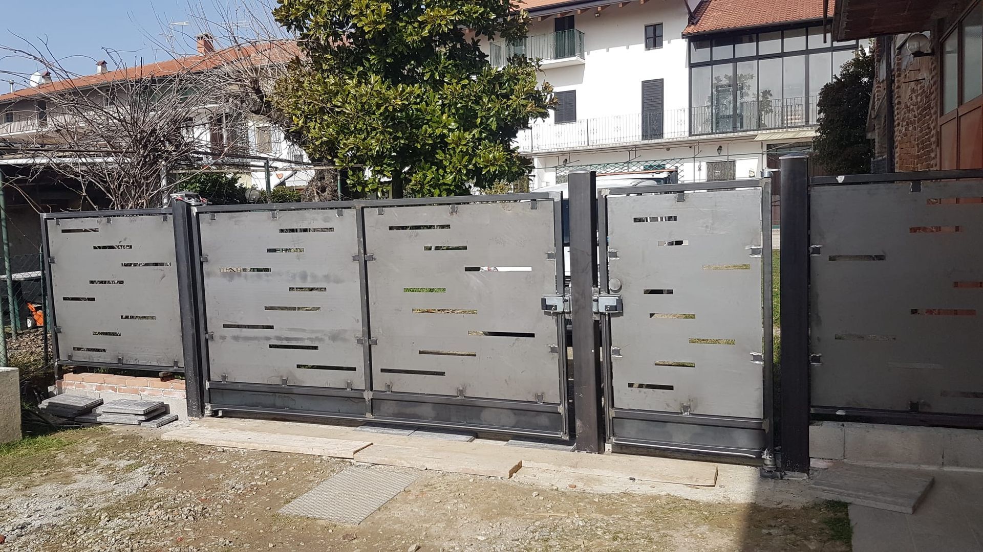 Una recinzione con un cancello e una casa sullo sfondo