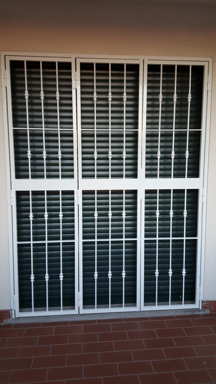 Una finestra bianca con persiane nere e telaio metallico