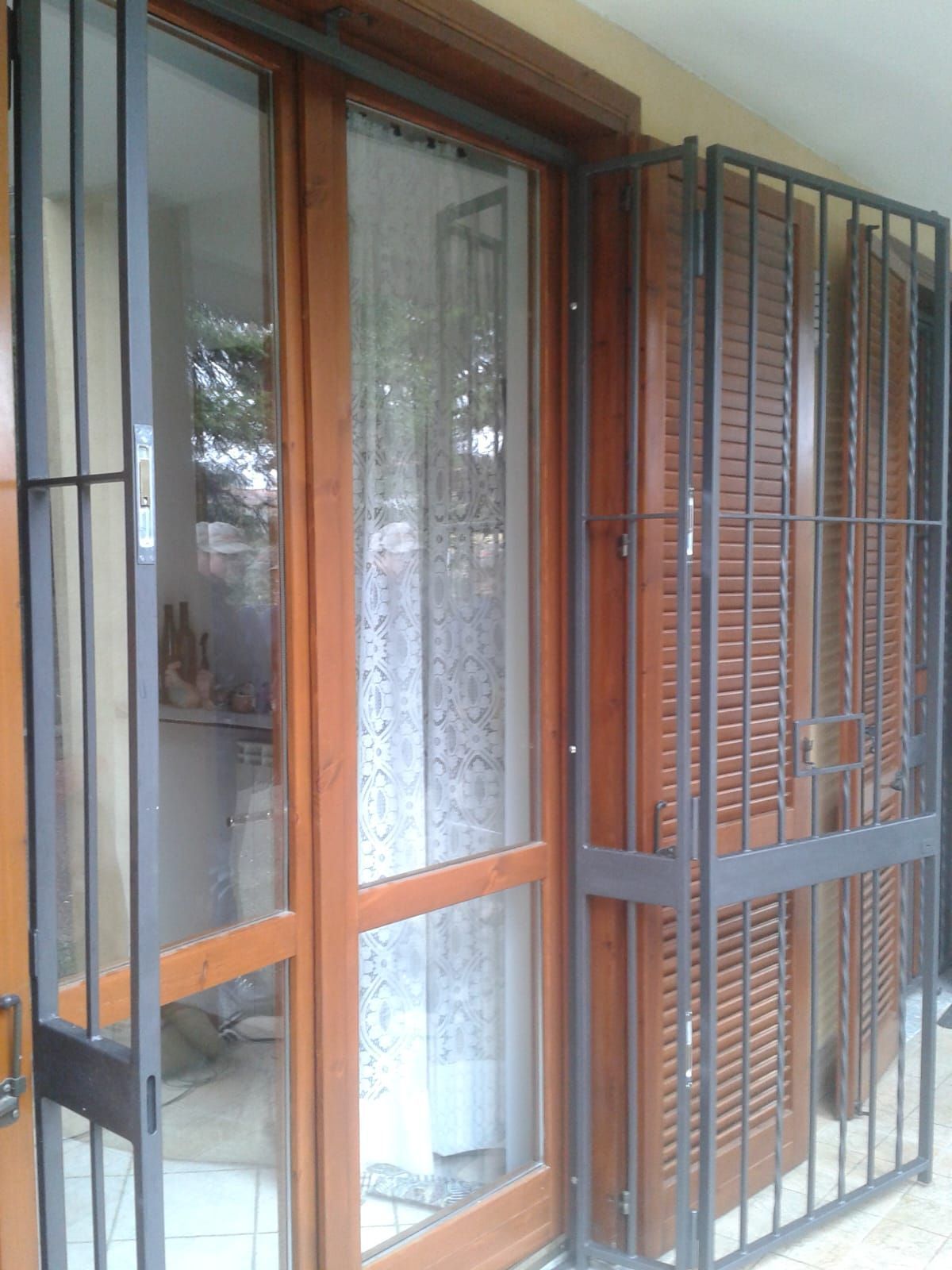 Una porta scorrevole in vetro con una recinzione metallica attorno.