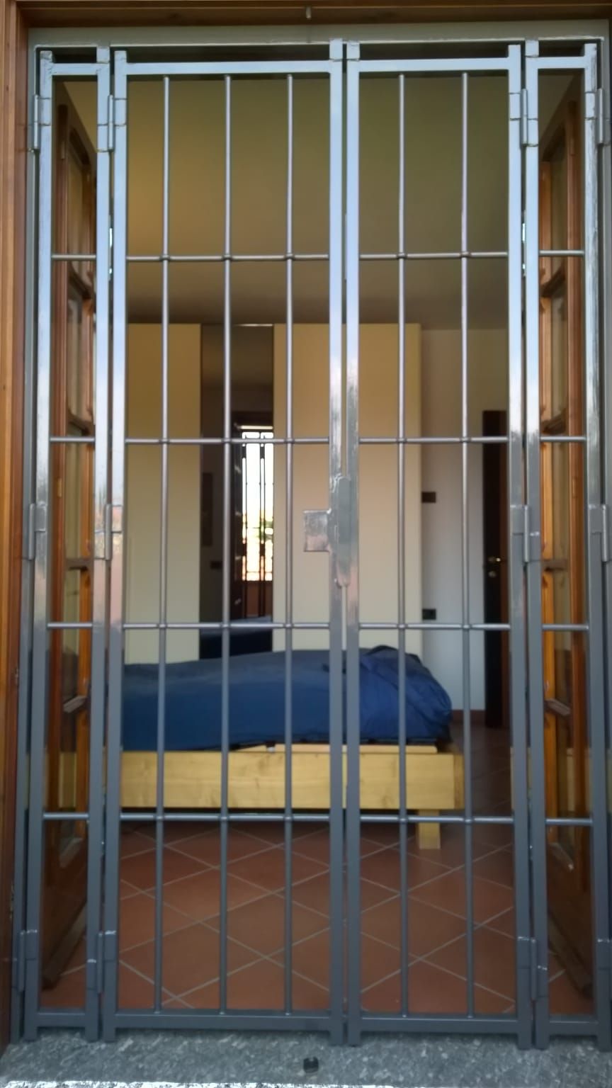 Una camera da letto con un letto dietro un cancello di metallo