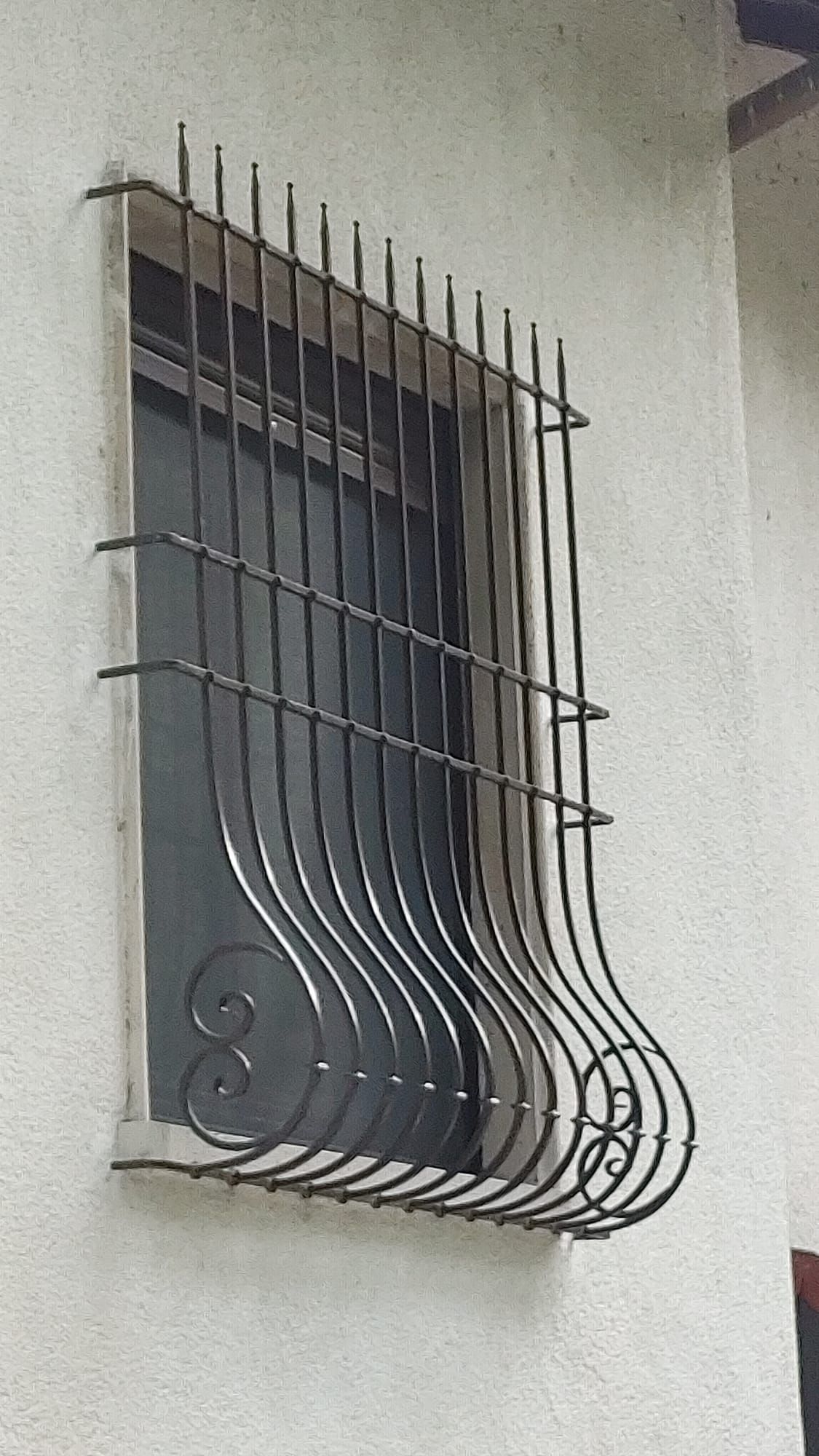 Una finestra con una grata in ferro battuto.