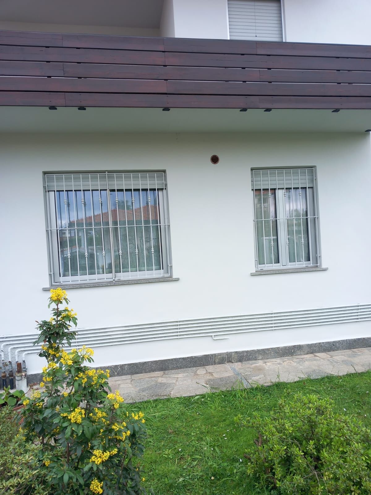 Una casa bianca con due finestre e un balcone