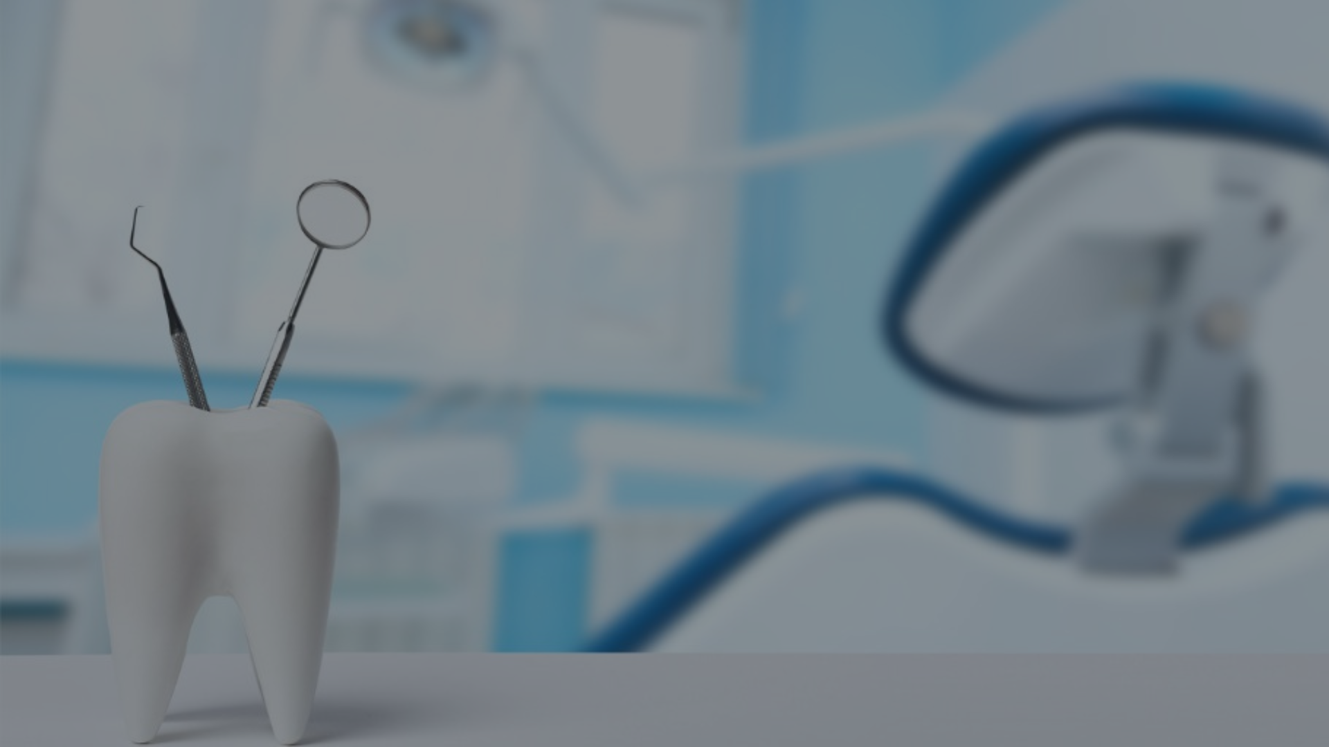 A tooth and dental instruments are on a table in a dental office.