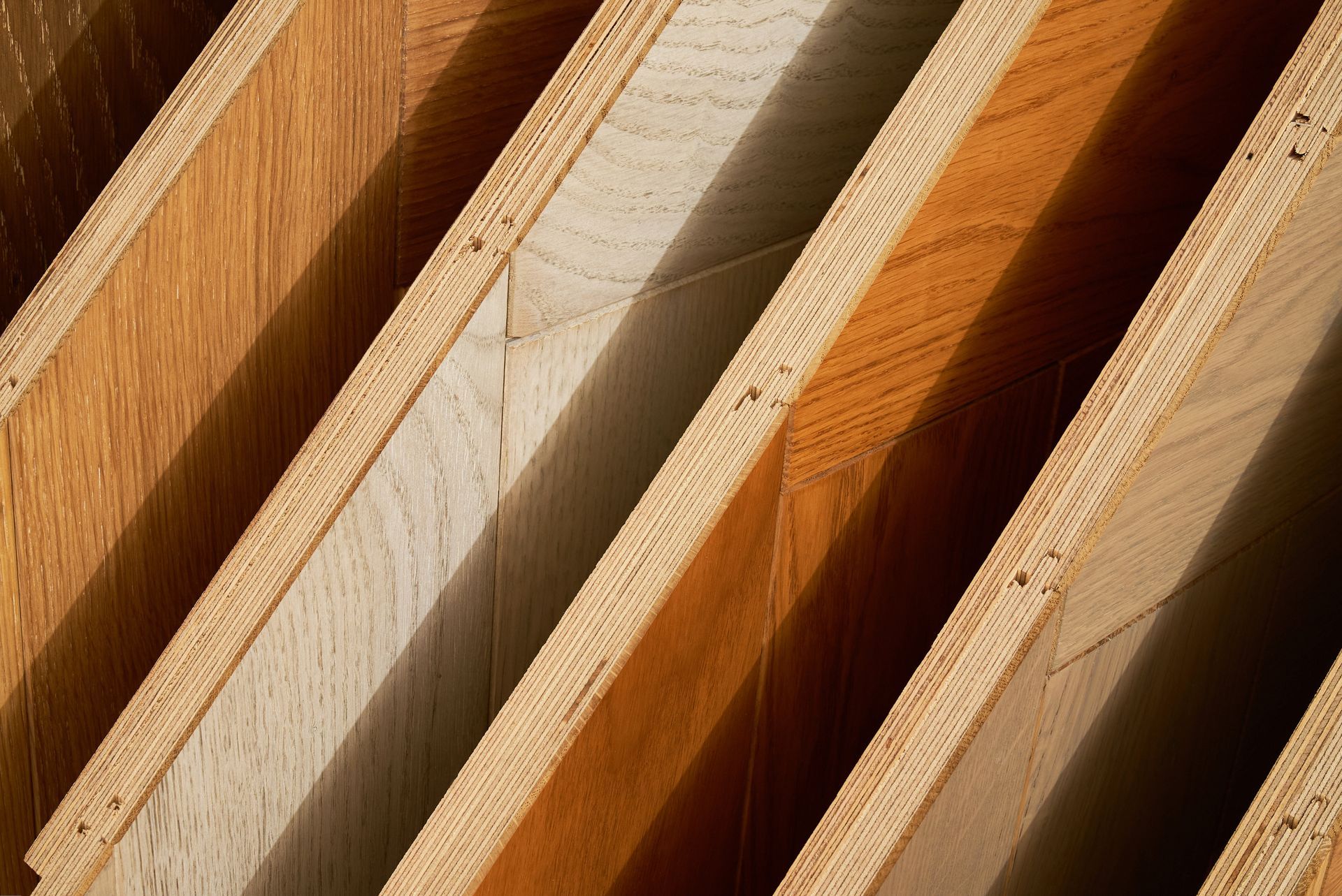 Various hardwood floor panels displayed upright to highlight grain patterns and colors. Various hardwood floor panels displayed upright to highlight grain patterns and colors.