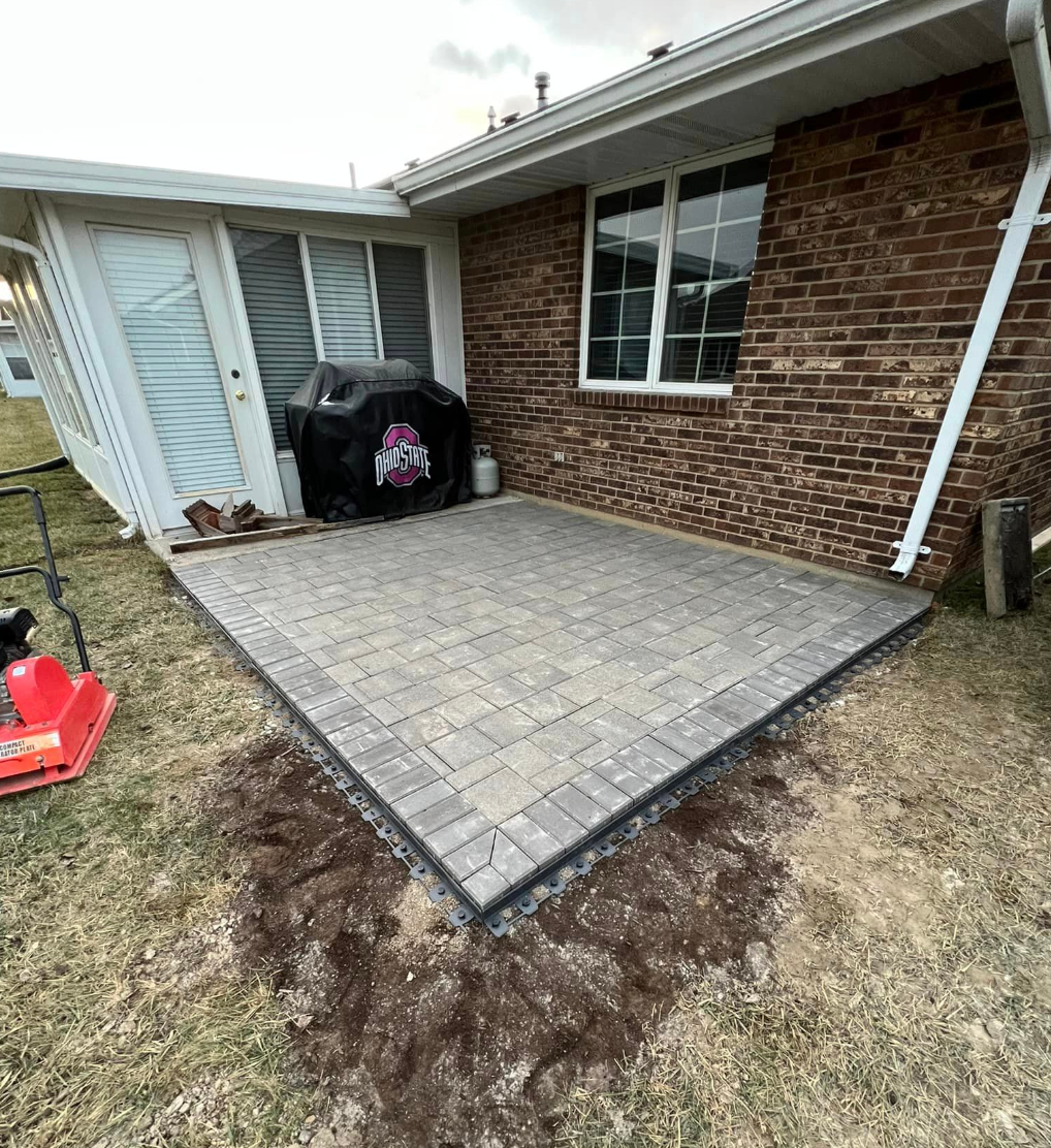 A brick house with a patio in front of it.