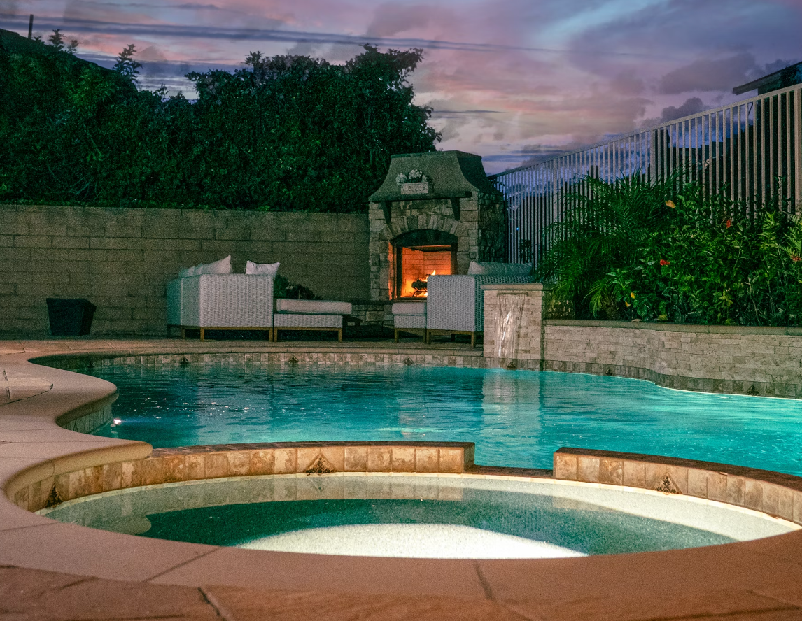 A large swimming pool with a fireplace in the background