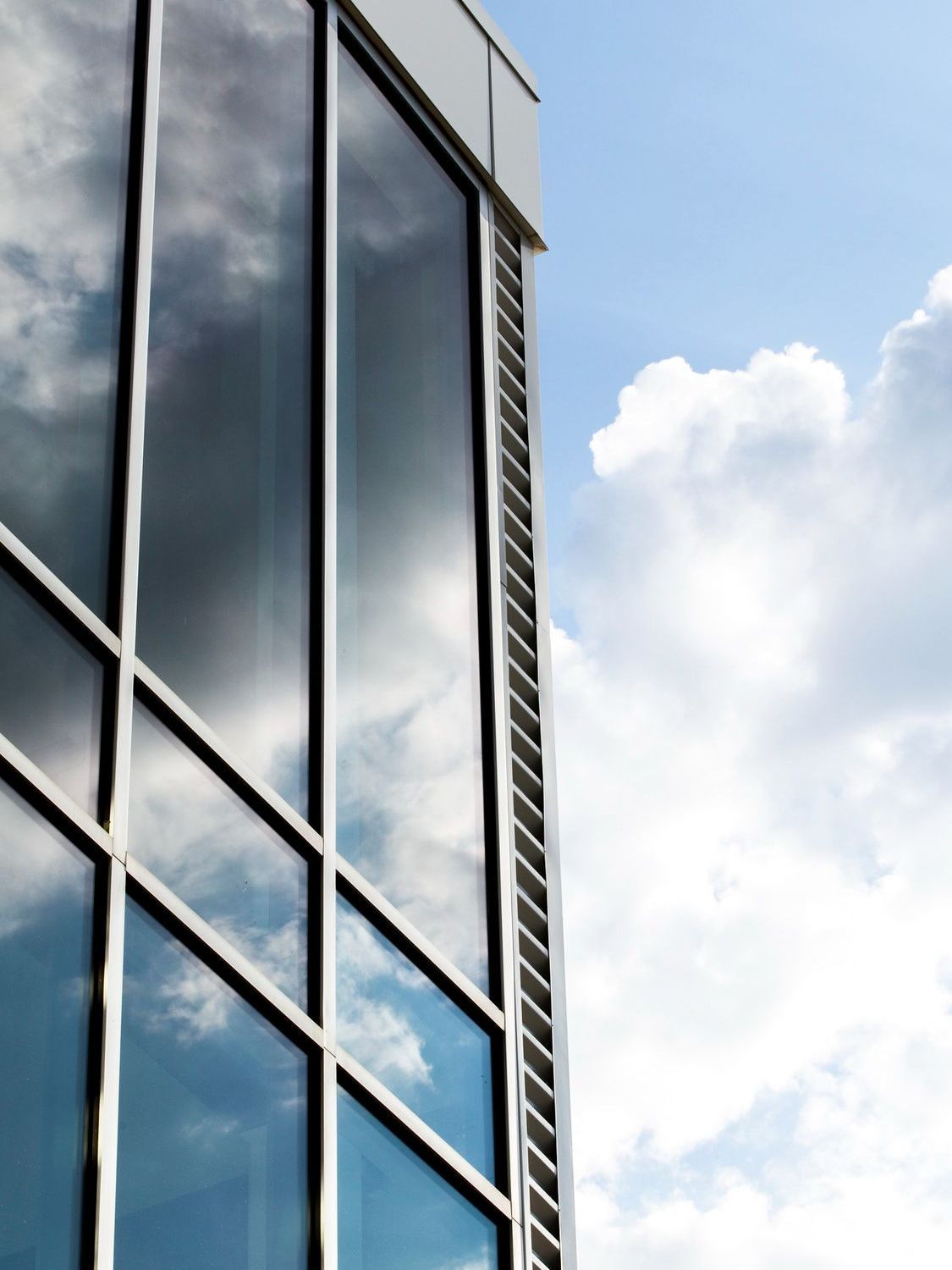 A building with a lot of windows reflecting the sky